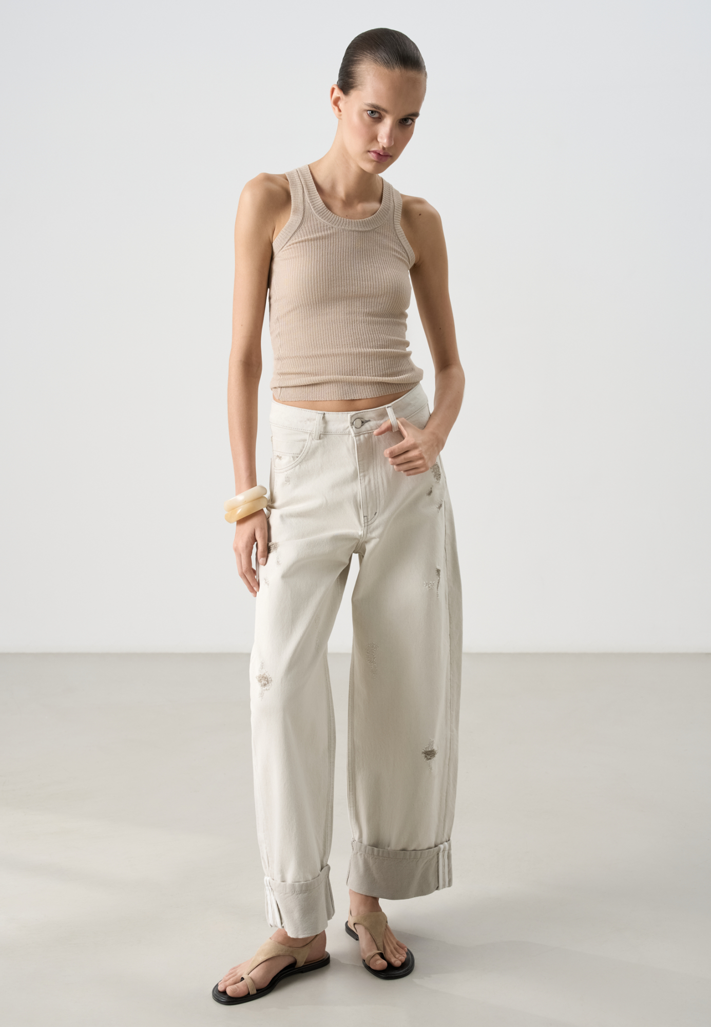 Трикотажный полупрозрачный топ из 100% хлопка. Модель приталенного силуэта, с глубокой проймой и круглым вырезом горловины. Изделие выполнено в рубчик.