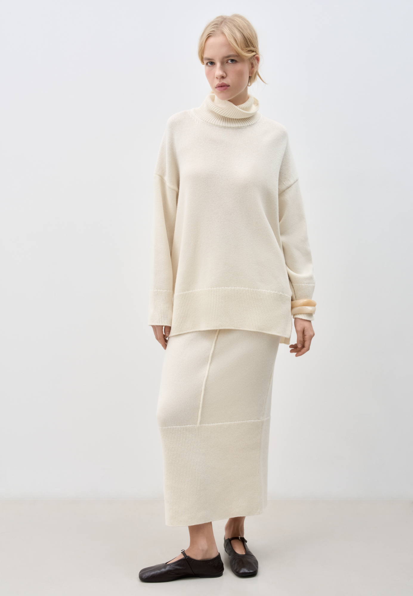 Юбка длины макси из кашемира и шерсти. Модель прямого силуэта, с широким эластичным поясом на кулиске. Изделие декорировано вертикальным валиком и невысоким разрезом сзади.