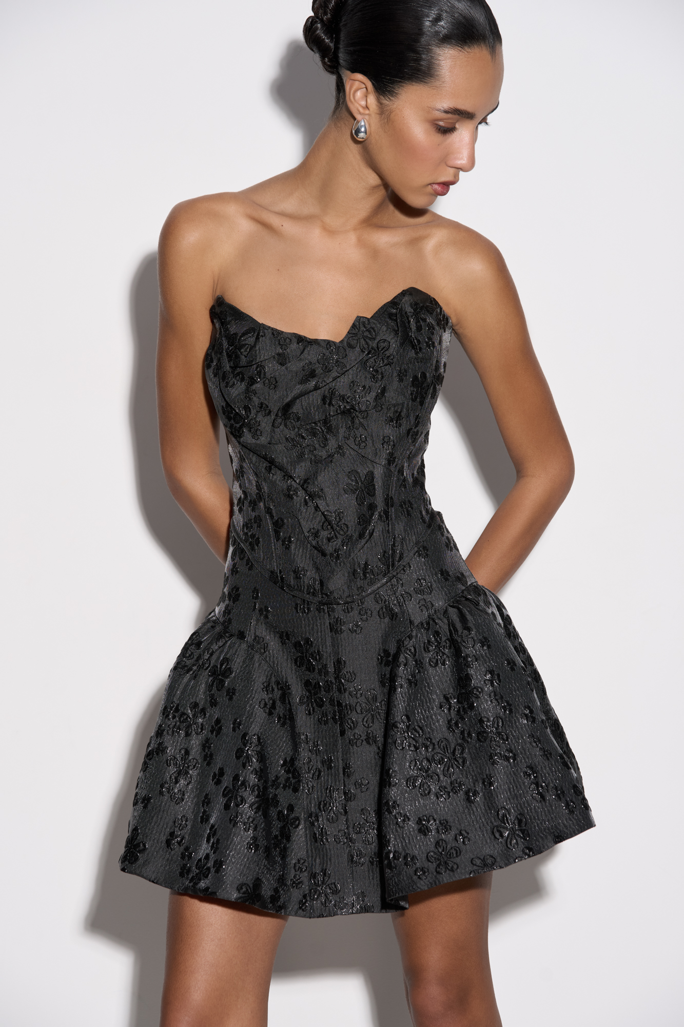 Юбка-баллон длины мини, выполненная из жатого жаккарда с растительным орнаментом. Модель с высокой талией и застежкой на скрытую молнию сзади. Изделие на подкладке.