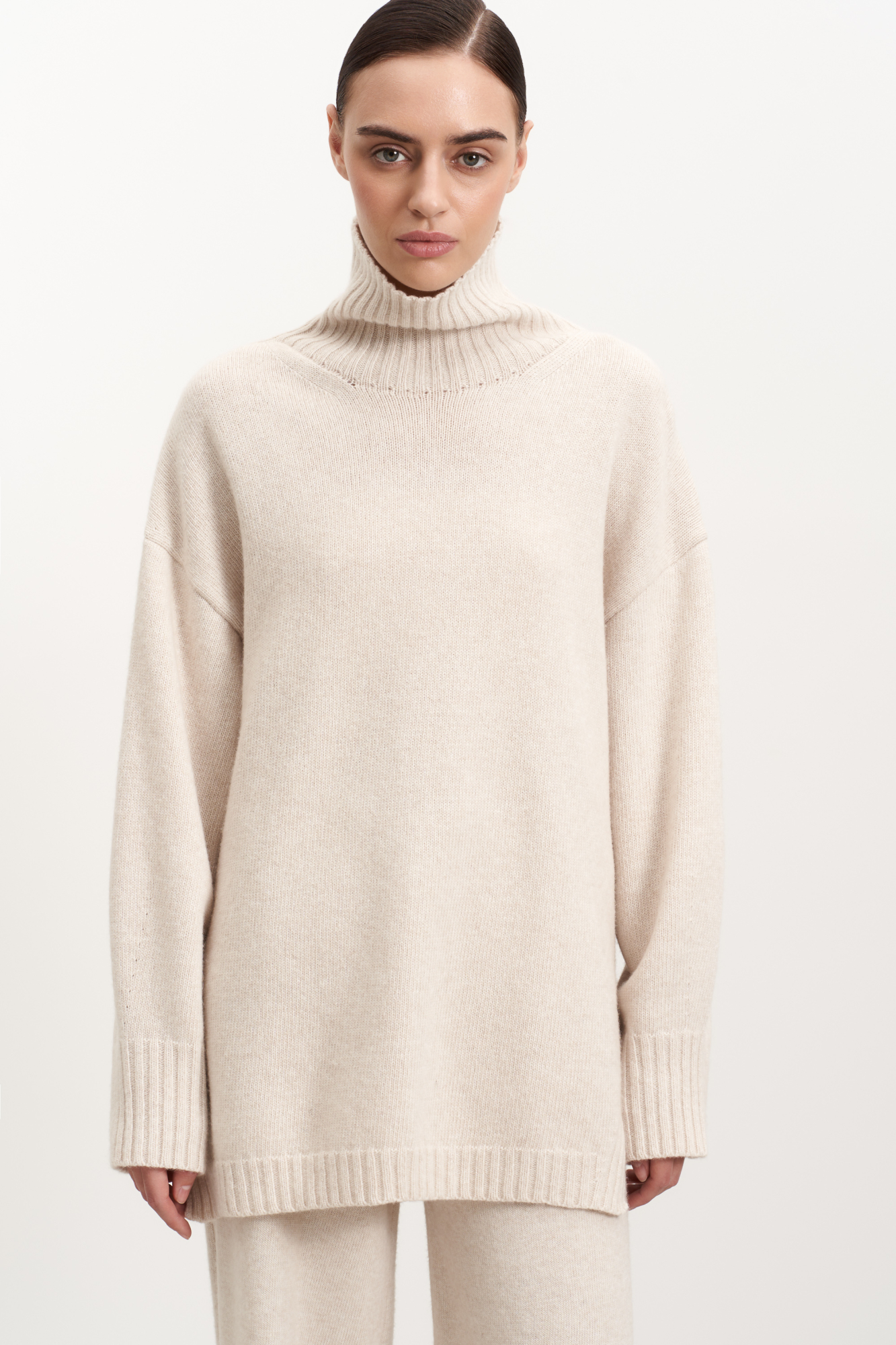 Джемпер свободного силуэта из кашемира и шерсти с высоким воротом и с боковыми разрезами.
