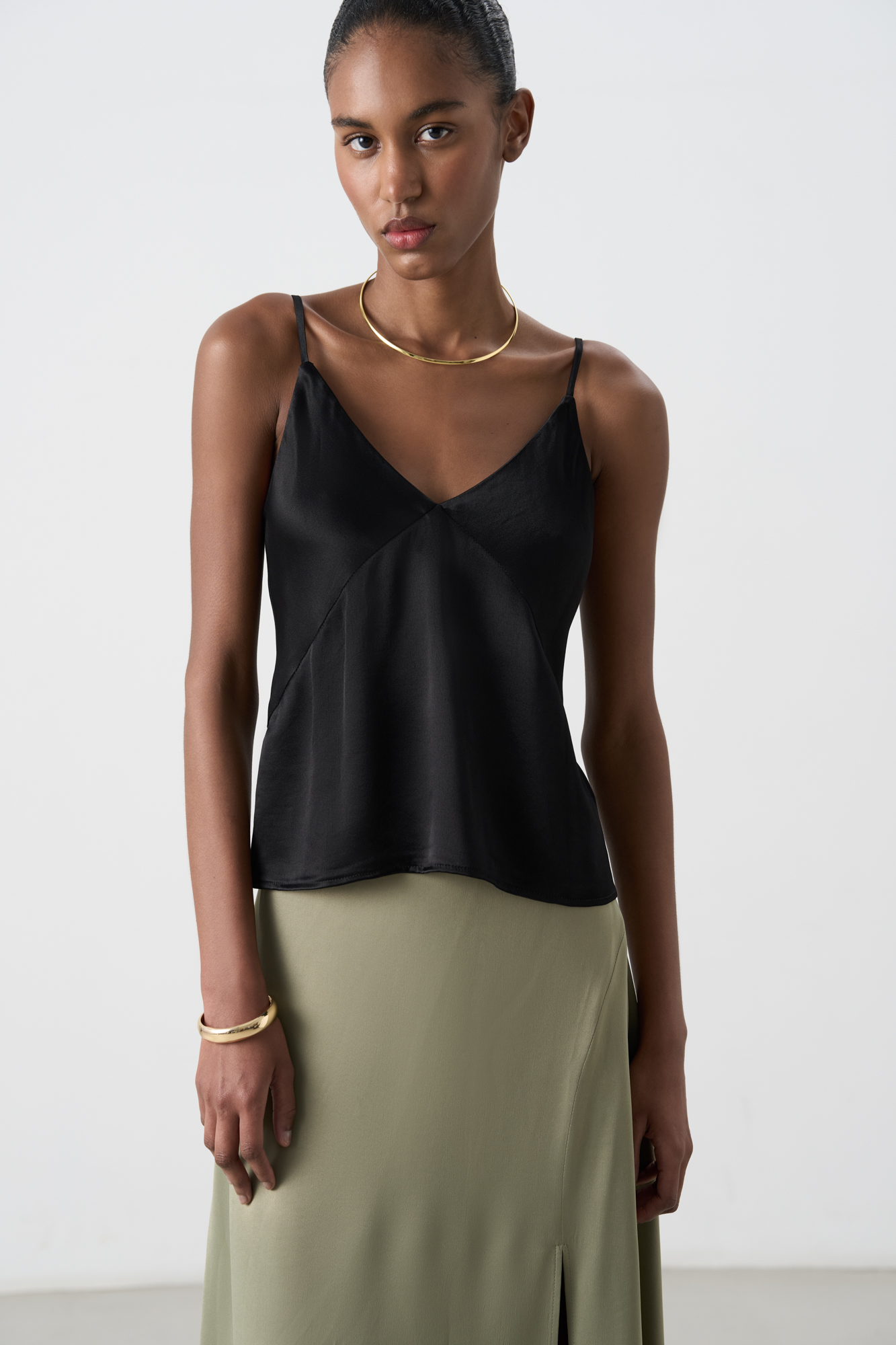 Атласный топ из тонкой вискозы. Модель прямого кроя, на тонких бретелях и глубоким V-образным вырезом.