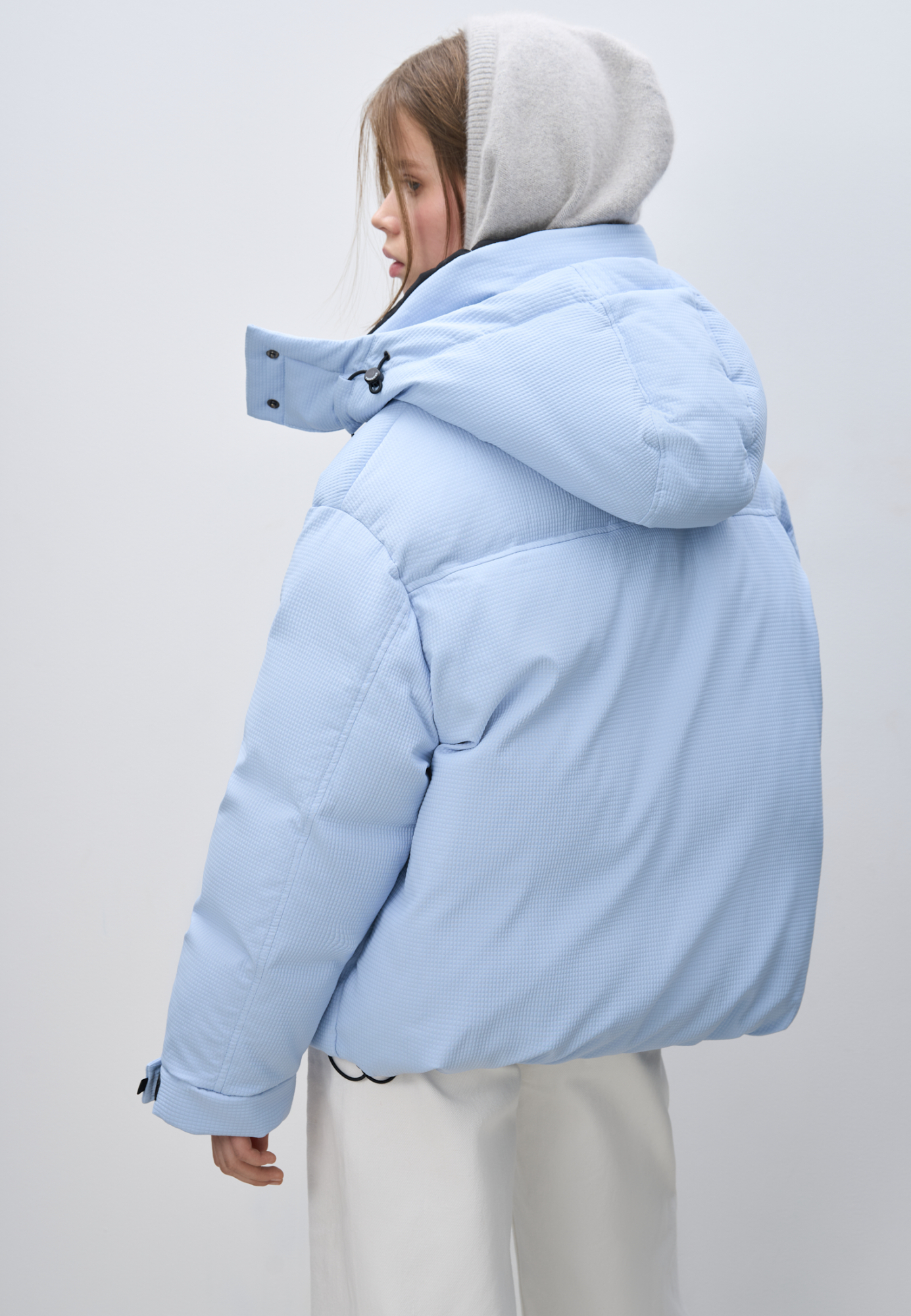 Пуховик с двумя нагрудными накладными карманами, воротником-стойкой и капюшоном. Застежка на молнию под планкой. Манжеты рукавов фиксируются липучкой. Низ изделия выполнен на регулируемой кулиске.