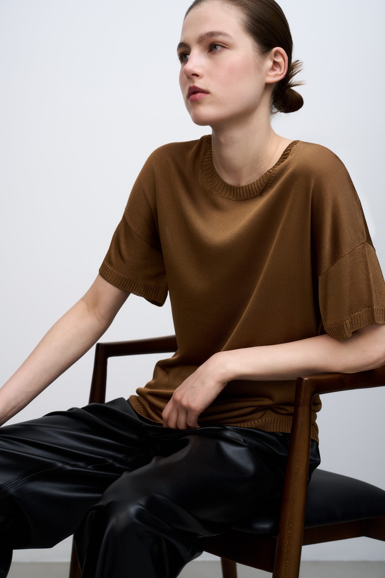 Цельновязаная футболка из 100% вискозы. Модель свободного силуэта, со спущенной линией плеча и круглым вырезом горловины. Края изделия выполнены в рубчик.