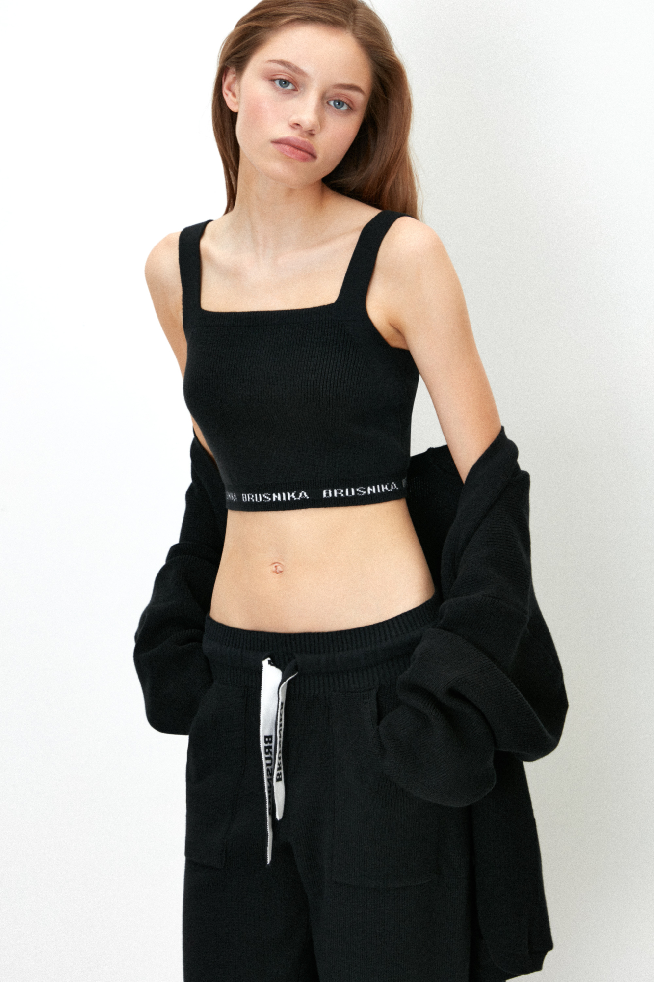 Трикотажный кроп-топ из хлопка с добавлением вискозы. Модель на широких лямках. по нижнему краю изделие декорировано контрастной вышивкой с названием бренда.