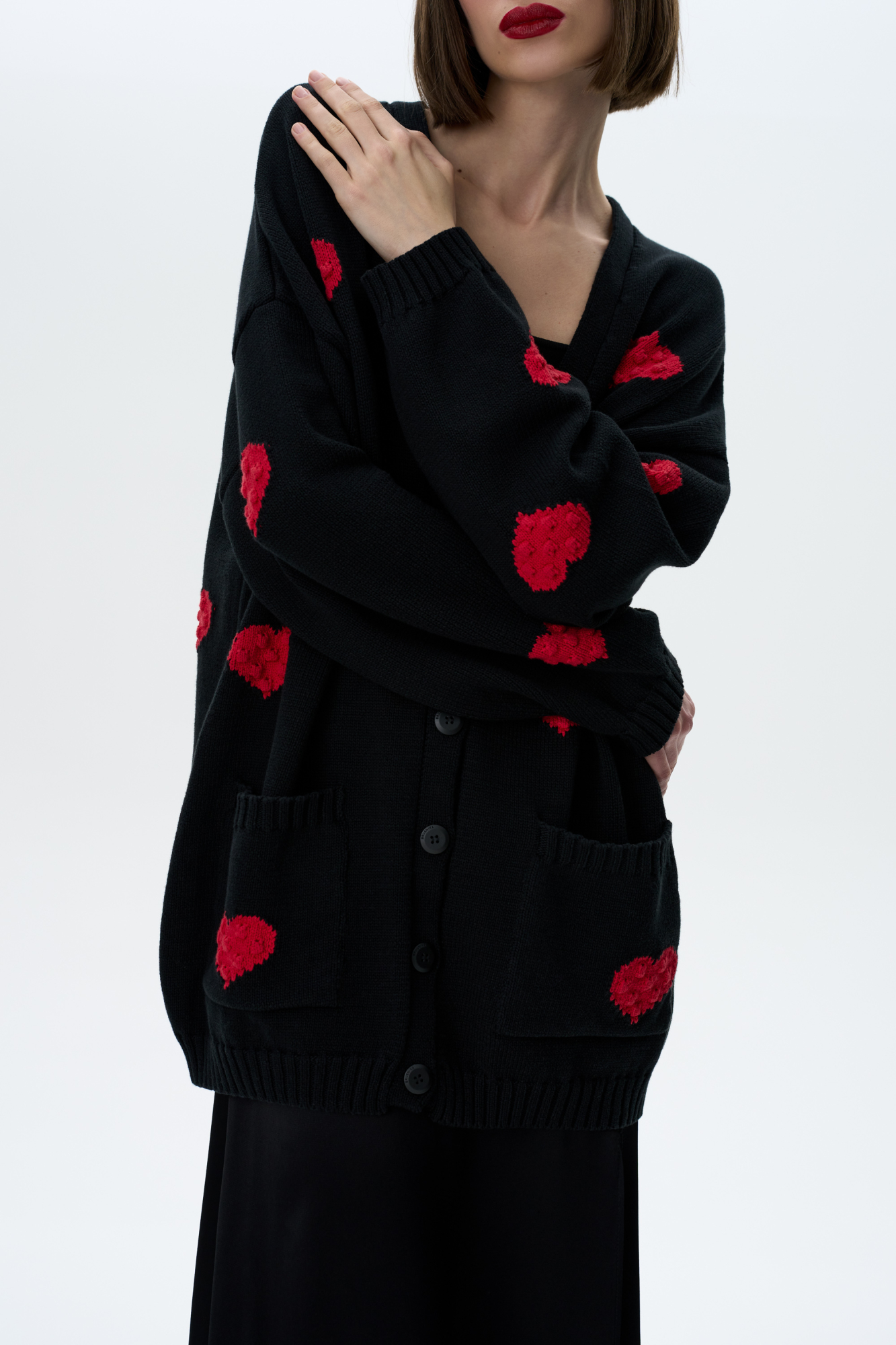 Свободный кардиган с V-образным вырезом и вывязанными&nbsp;&nbsp;сердцами. Застежка на пуговицы.