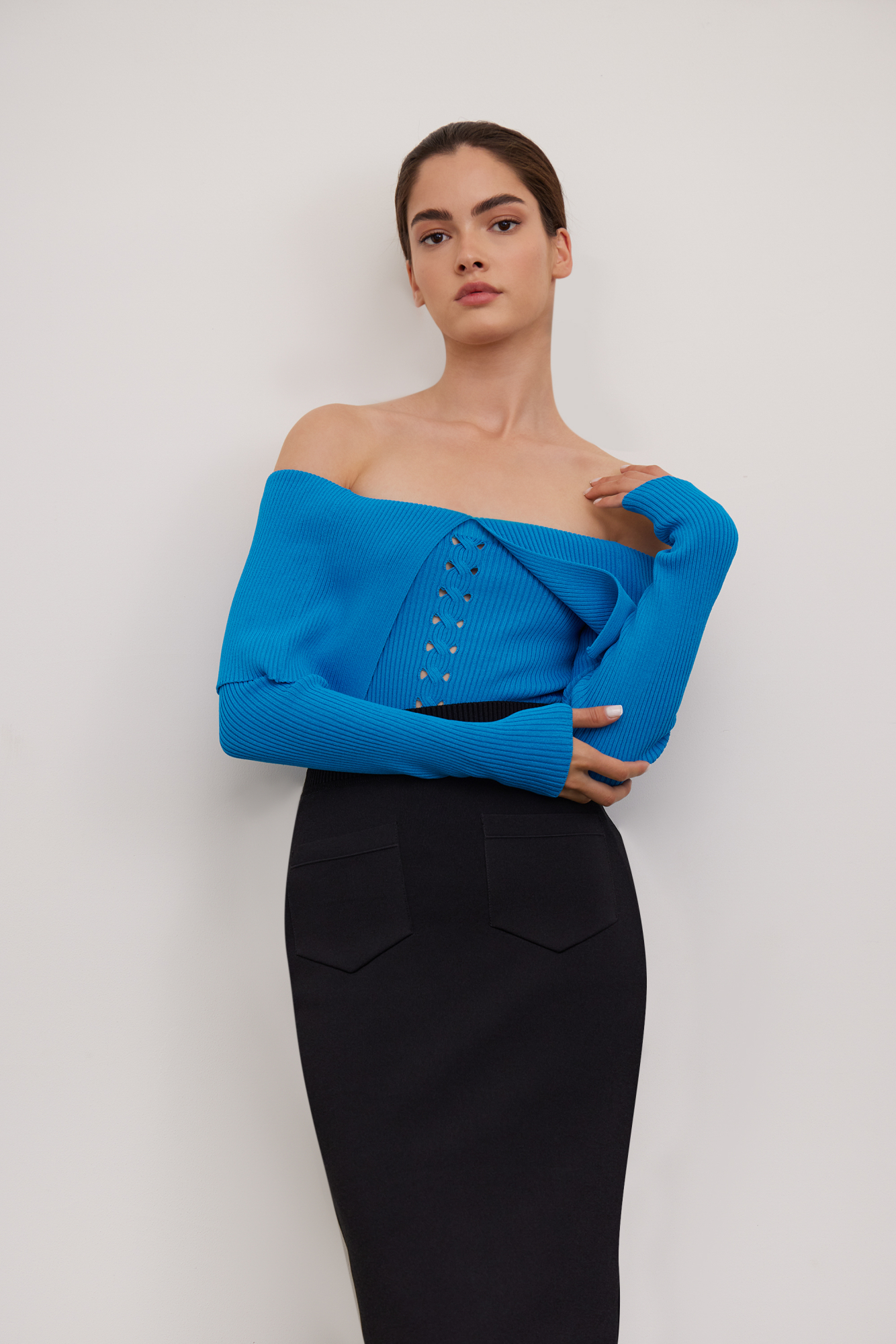 Приталенный топ из вискозы с длинным рукавом и открытыми плечами. Модель декорирована вывязанным орнаментом в виде косы и широкой отлетной деталью.