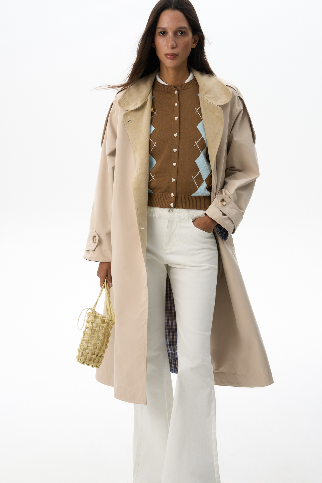 Двусторонний однобортный тренч с воротником-стойкой. Модель формы трапеция свободного кроя, глубокими карманами, патами на плечах и манжетах рукавов. Застежка на пуговицы. Одна сторона выполнена из гладкой плащевой ткани, вторая - из принтованной ткани в клетку с отделкой лацконов и планки под замшу.