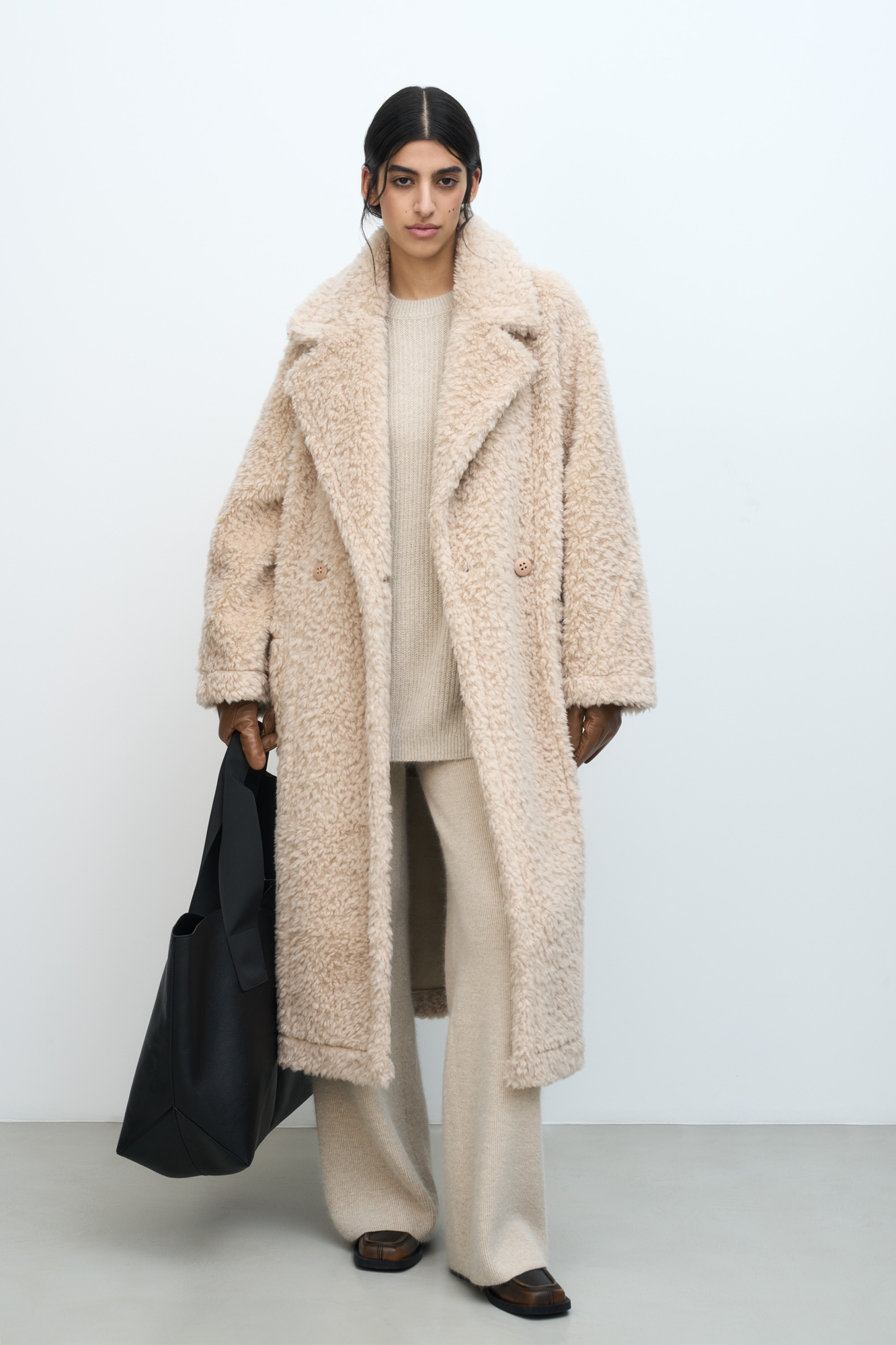 Двусторонняя шуба, выполненая из натуральной шерсти и экокожи. Модель свободного силуэта с отложным воротником и накладными карманами. Застежка на пуговицы.