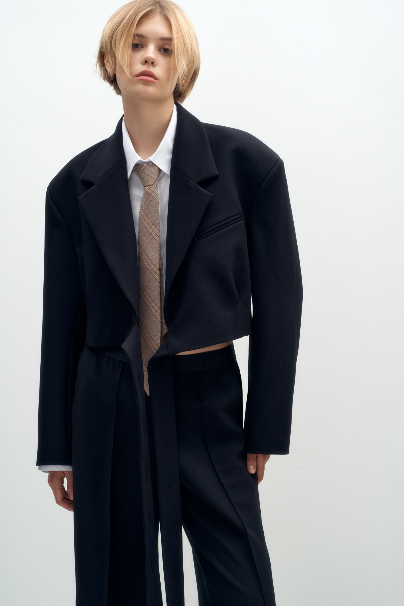 Укороченный жакет на запах с поясом. Отложной воротник с прямоугольными лацканами и декоративный нагрудный карман с кантом. Модель приталенного силуэта с подкладкой, манжеты на пуговицах.