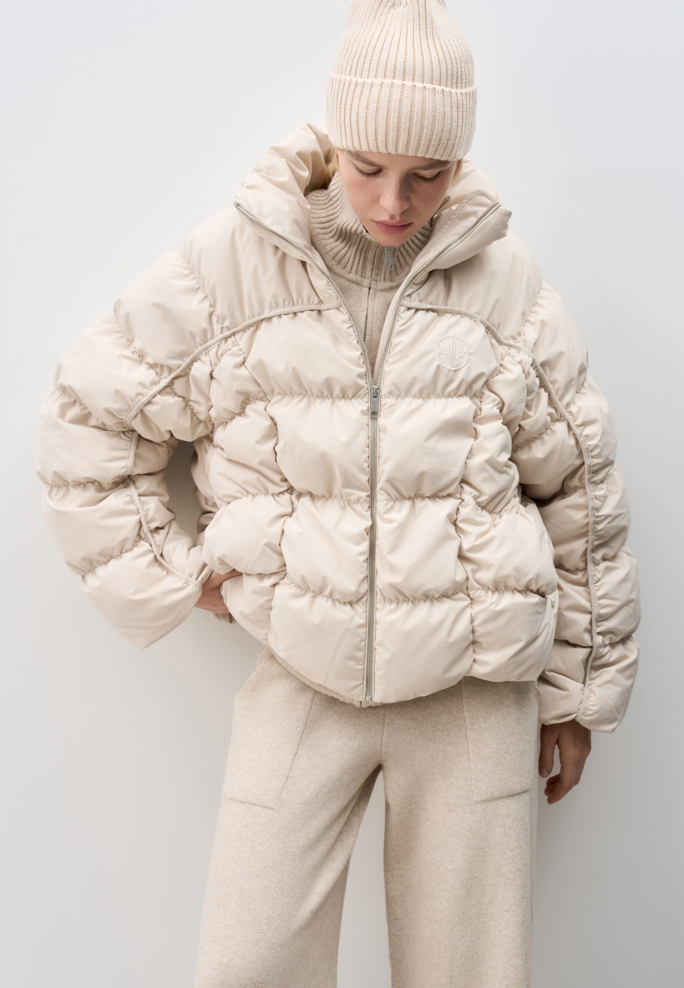 Стеганый пуховик с воротником-стойкой. Застежка на молнию. Низ изделия выполнен на регулируемой кулиске. Вышитый логотип на груди. На подкладке. 