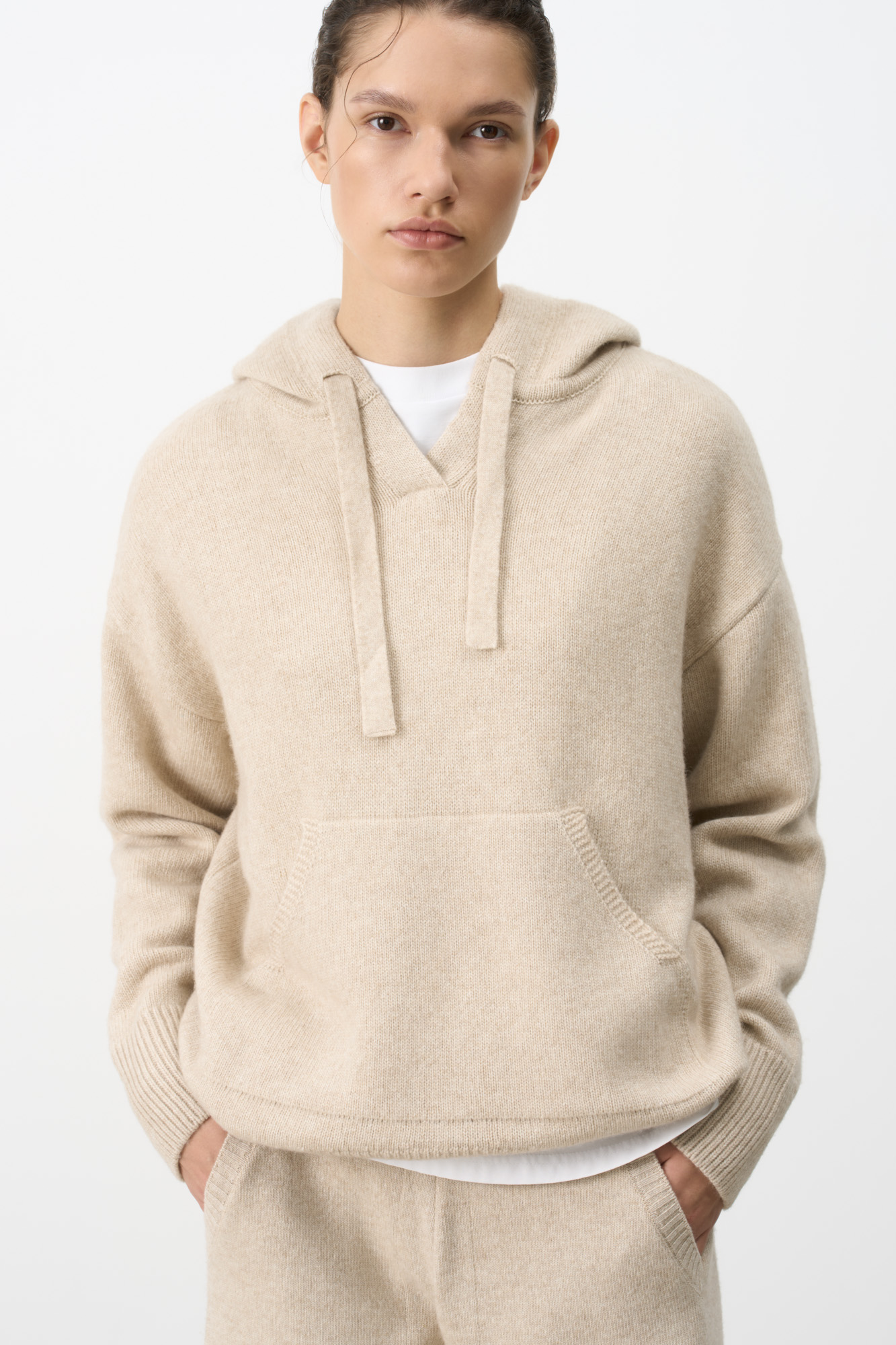 Трикотажное худи из кашемира и шерсти. Модель свободного силуэта, со спущенной линией плеч, глубоким капюшоном на кулиске и карманом-кенгуру. Края изделия выполнены в рубчик.
