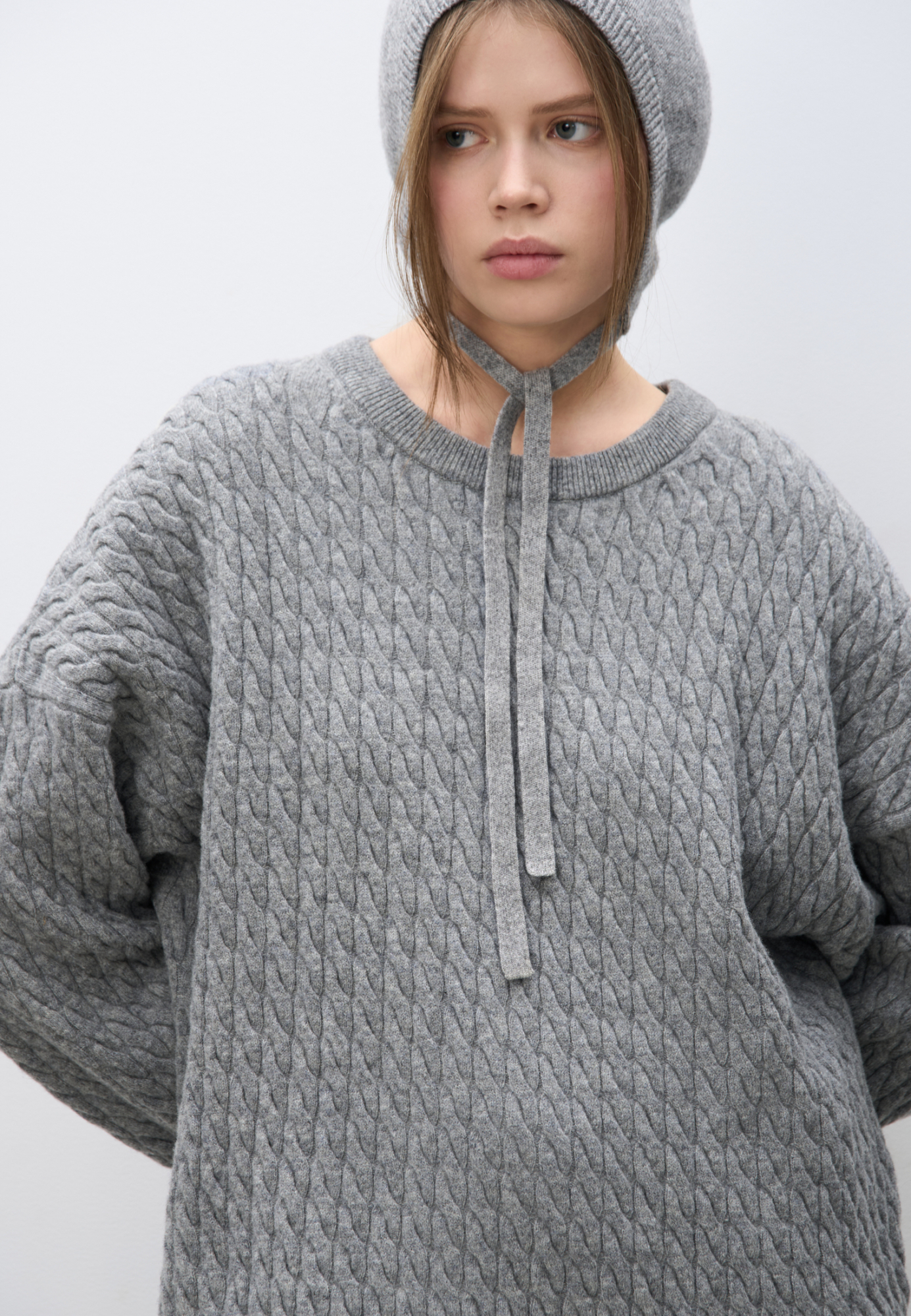 Трикотажный джемпер с объемными косами из 100% шерсти мериноса экстрафайн. Модель свободного силуэта, со спущенной линией плеч и круглым вырезом горловины, оформленным двойной бейкой. Края изделия выполнены в мелкий рубчик.