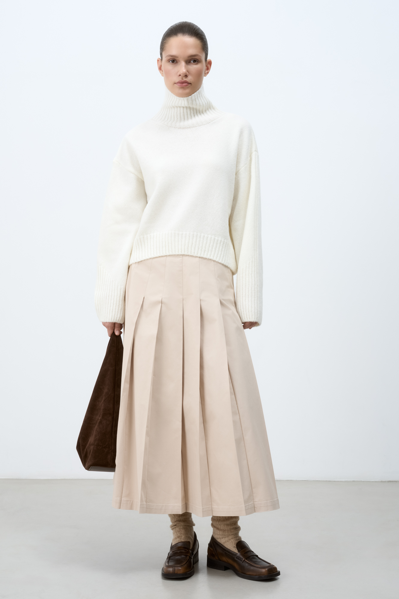 Джемпер из шерсти мериноса экстрафайн. Модель свободного силуэта с высоким воротом. Воротник, манжеты и низ изделия выполнены в широкий рубчик. Рубчик на манжетах образует асимметричный узор и с внешней стороны рукава продолжается до плеча. 