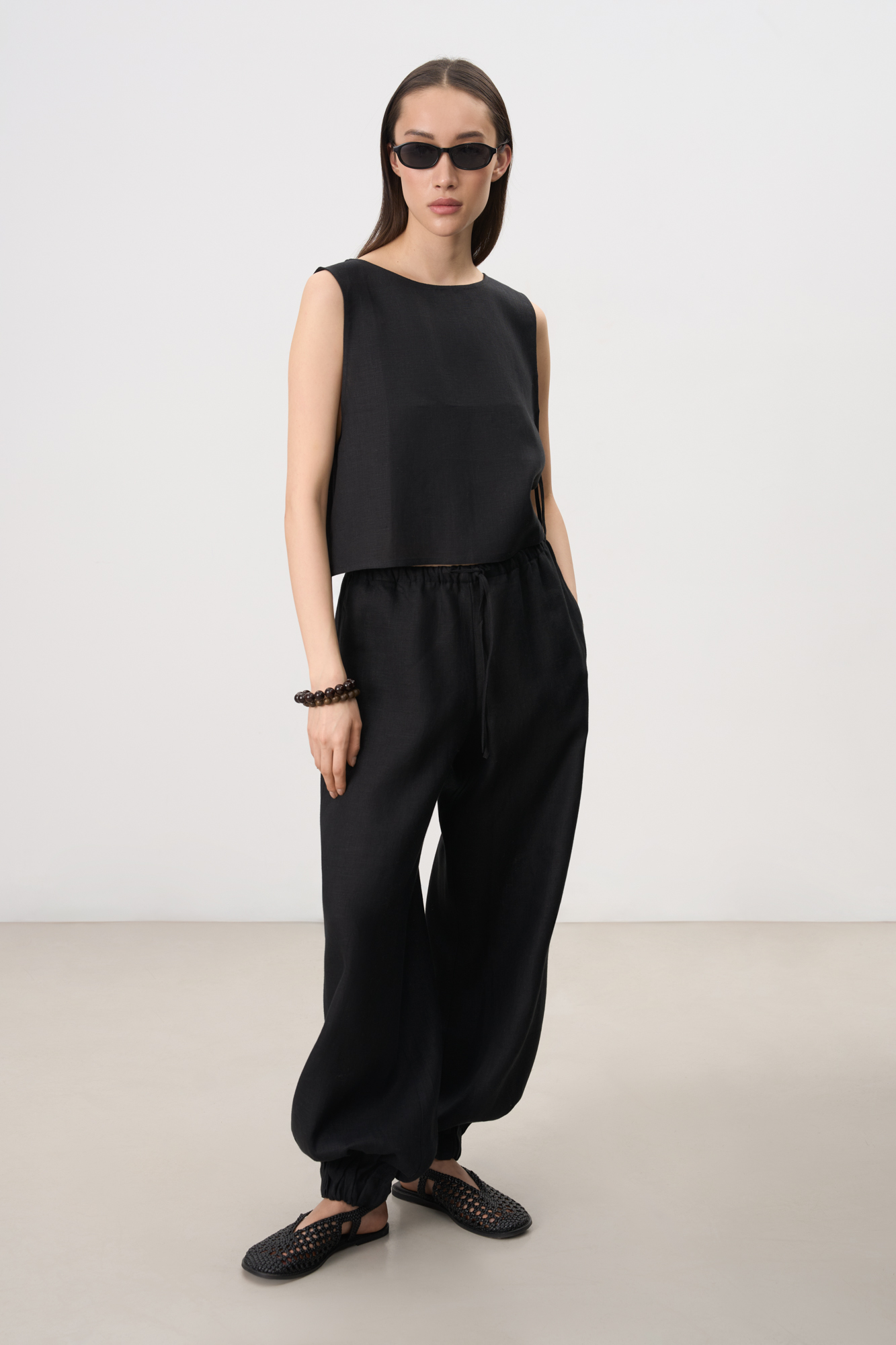 Укороченный топ из 100% льна. Модель свободного кроя, без рукавов, с круглым вырезом горловины. Изделие фиксируется завязками по бокам.