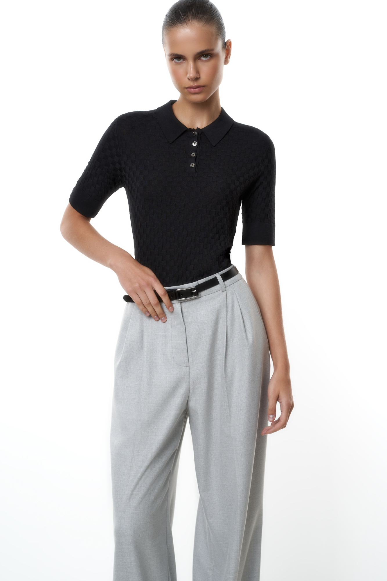 Трикотажная футболка-поло из вискозы. Модель приталенного силуэта, с короткими рукавами с манжетами, отложным воротником и застежкой на пуговицы на планке.