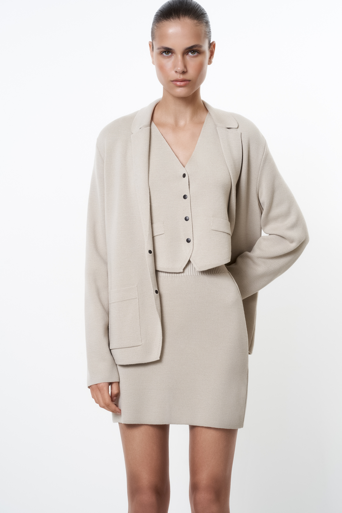 Трикотажная юбка длины мини из шерсти мериноса. Модель с боковой планкой на кнопках, небольшим вырезом сбоку, накладными карманами сзади и широким эластичным поясом на резинке. Дополнить образ можно жилетом, жакетом или бомбером.