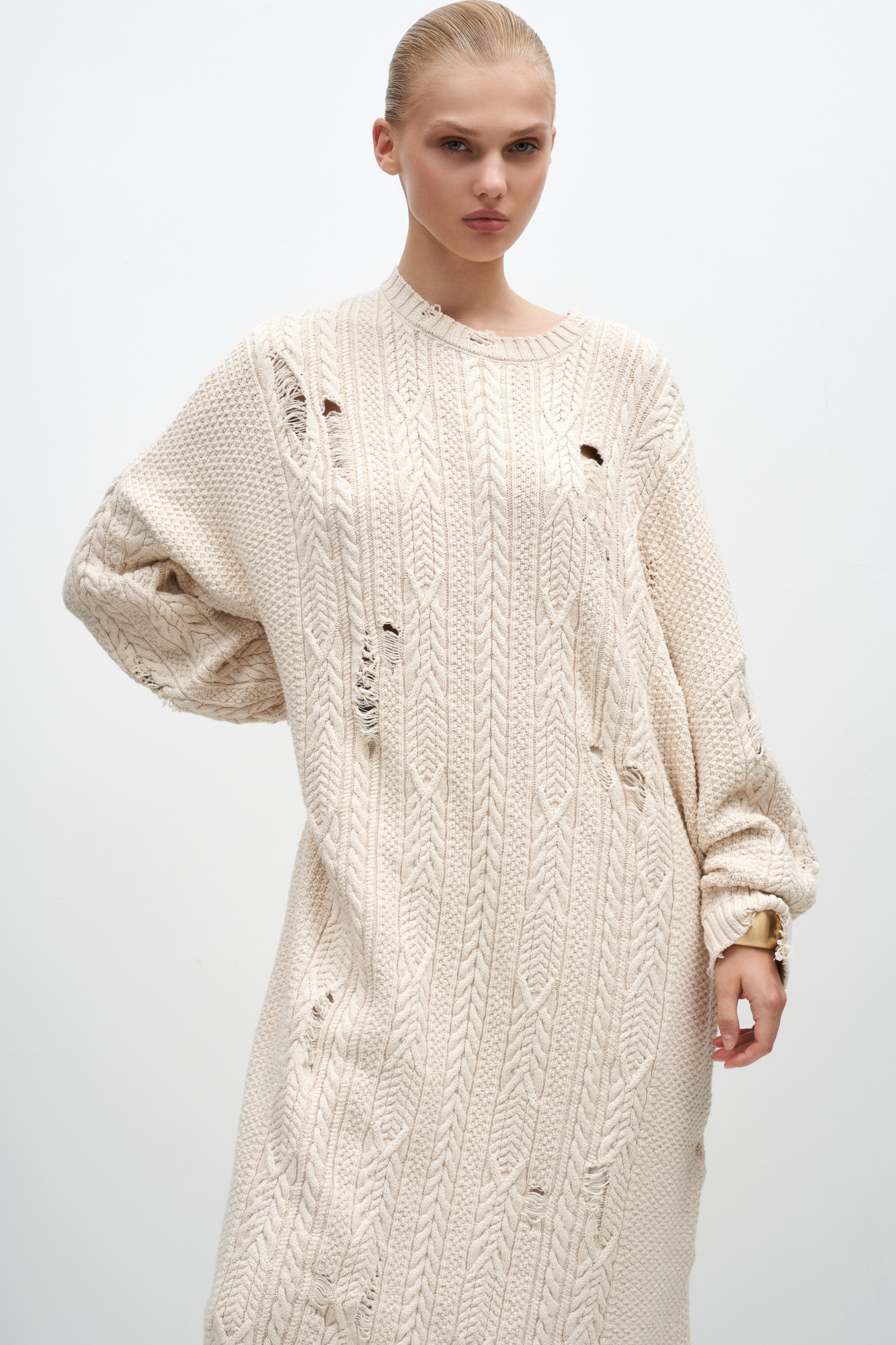 Трикотажное платье с разрезами в стиле гранж. Модель свободного силуэта длины миди, со спущенным плечом и круглым вырезом.