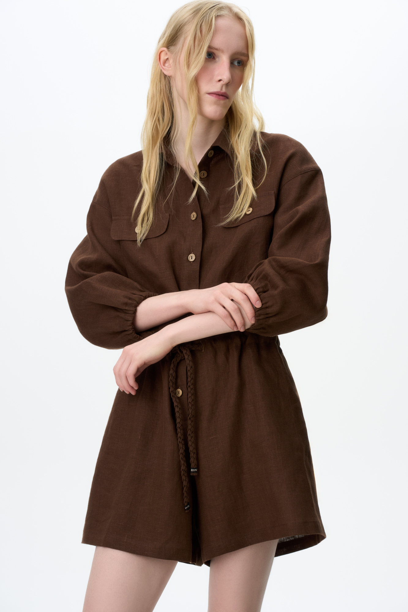 Комбинезон из 100% льна. Модель с рубашечным верхом, отложным воротником, накладными карманами на груди, длинными рукавами и застежкой на пуговицы. Регулируемая кулиска на поясе.