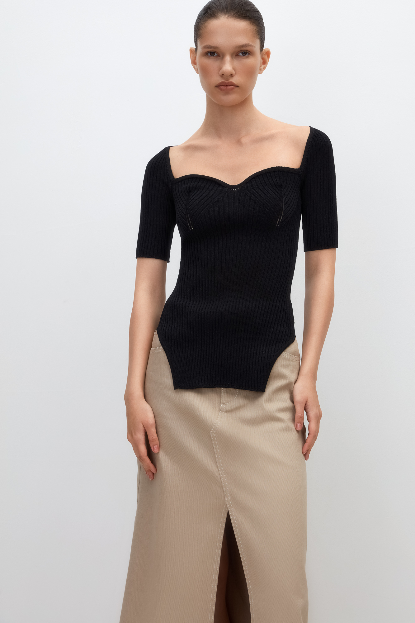 Трикотажный удлиненный топ из вискозы. Модель с вывязанным декольте и короткими рукавами.