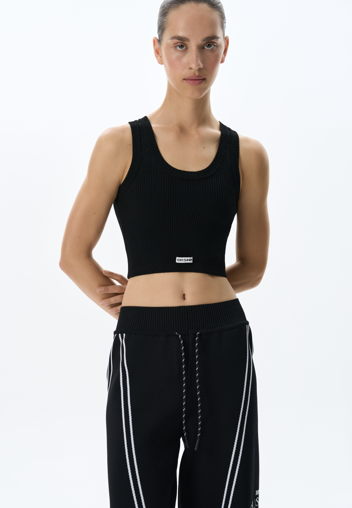 Трикотажный короткий топ из вискозы. Модель по фигуре, без рукавов и U-вырезом головины. Изделие выполнено в рубчик и декорирован брендированным жаккардом спереди.