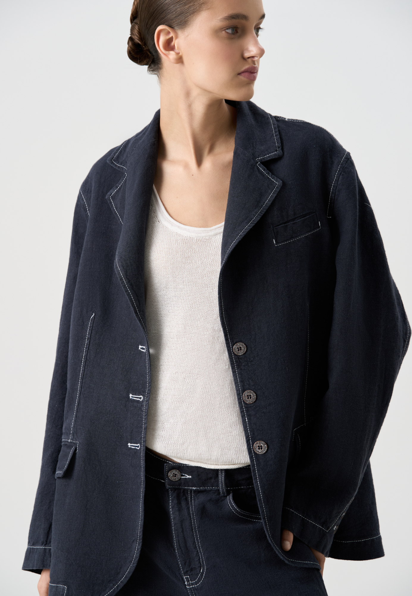 Классический однобортный жакет из 100% льна. Модель прямого кроя, с широкими лацканами и застежкой на три пуговицы. Нагрудный и два прорезных кармана с клапанами. Изделие декорировано строчкой контрастного цвета. 