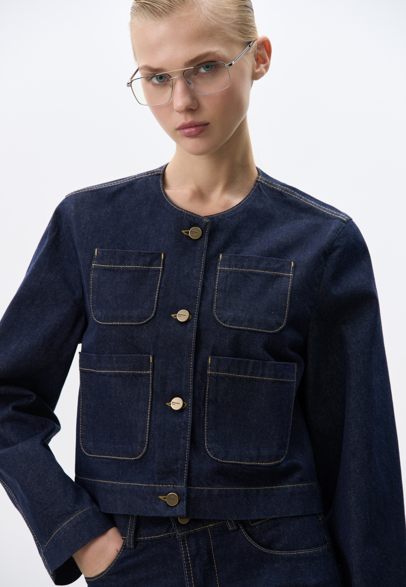 Укороченный джинсовый жакет из 100% хлопка. Модель прямого кроя, с накладными карманами и застежкой на металлические пуговицы. Изделие без подкладки. Дополнить образ можно джинсами.