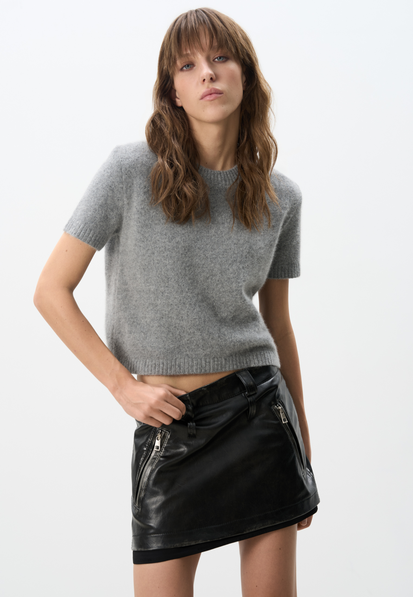 Юбка длины мини из экокожи. Модель по фигуре, со шлевками на поясе для ремня и карманами сзади. Изделие декорировано имитацией потертостей по швам и логотипом бренда. На подкладке. Застежка на молнию сбоку.