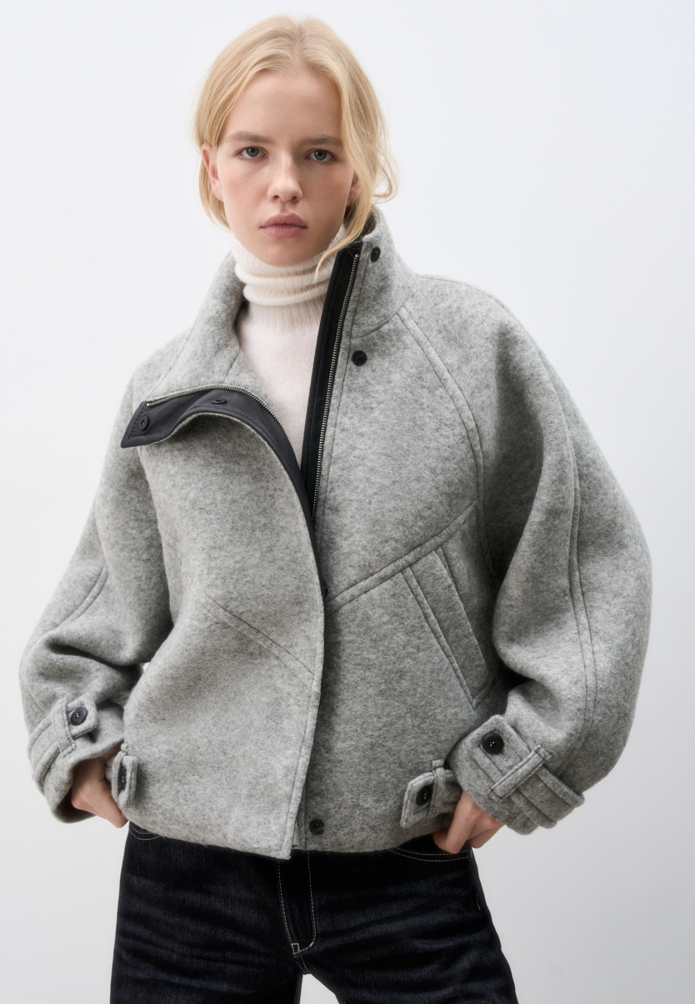 Шерстяной бомбер с воротником-стойкой. Модель свободного силуэта, с патами на пуговицах на манжетах и по низу изделия, застежка на молнию и магнитные пуговицы под планкой, декорированной экокожей. Бомбер выполнен на подкладке.
