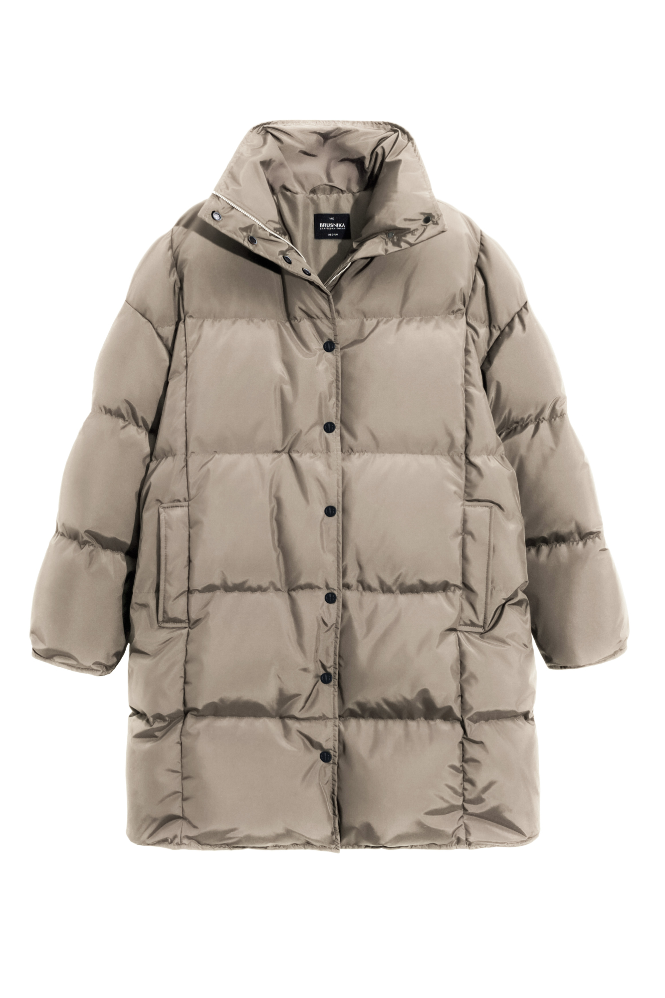 Длинный стеганый пуховик с капюшоном на кулиске. Модель свободного силуэта с воротником-стойкой, трикотажными манжетами и боковыми карманами. Застежка на молнию под планкой с брендированными пуговицами.
