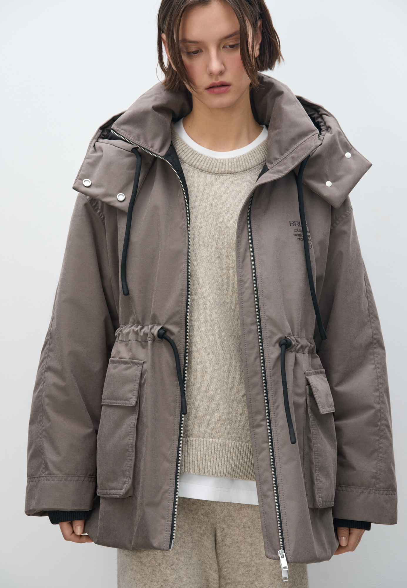 Парка на синтепоне. Модель свободного силуэта с регулируемой кулиской на талии, большими накладными карманами с клапанами, со спущенной линией плеч и воротником-стойкой. В комплекте к куртке идет дополнительный объемный воротник и капюшон. Застежка на молнию. Изделие выполнено на подкладке.