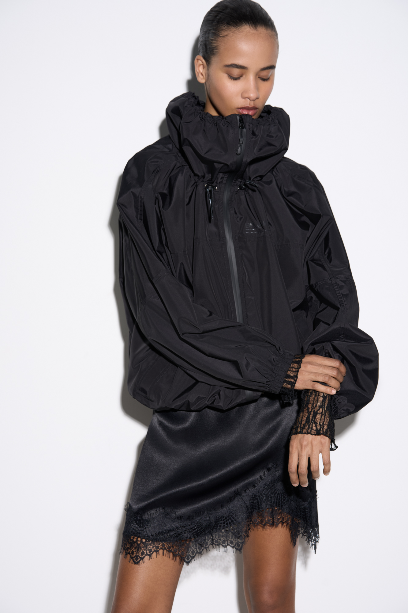 Куртка-ветровка из полиэстра. Модель свободного силуэта с высоким воротником-стойкой на регулируемой кулиске, карманами и застежкой на молнию. Манжеты рукавов выполнены на резинке. Логотип бренда на груди.