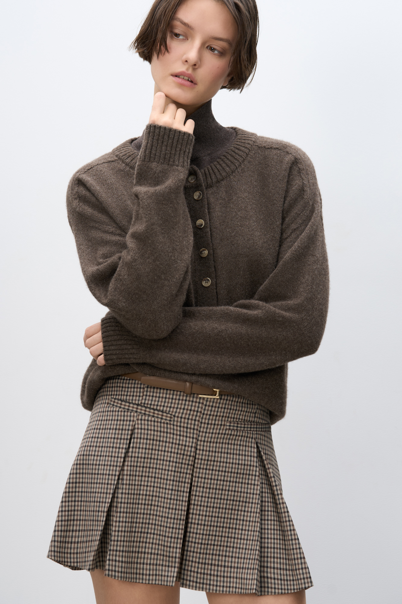 Юбка длины мини в клетку виши из шерсти. Модель прямого кроя, с крупными складками, поясом со шлевками для ремня, врезными карманами спереди и застежкой на молнию. Изделие без подкладки.