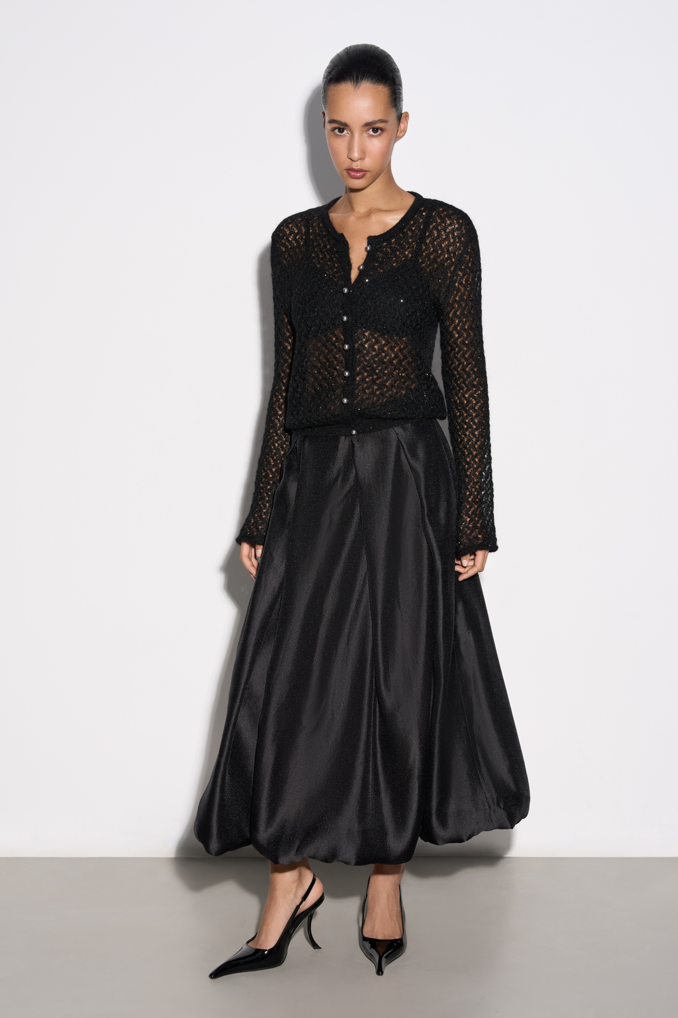 Юбка-баллон длины миди из атласной ткани. Модель выполнена в крупную складку. Застежка на потайную молнию. 