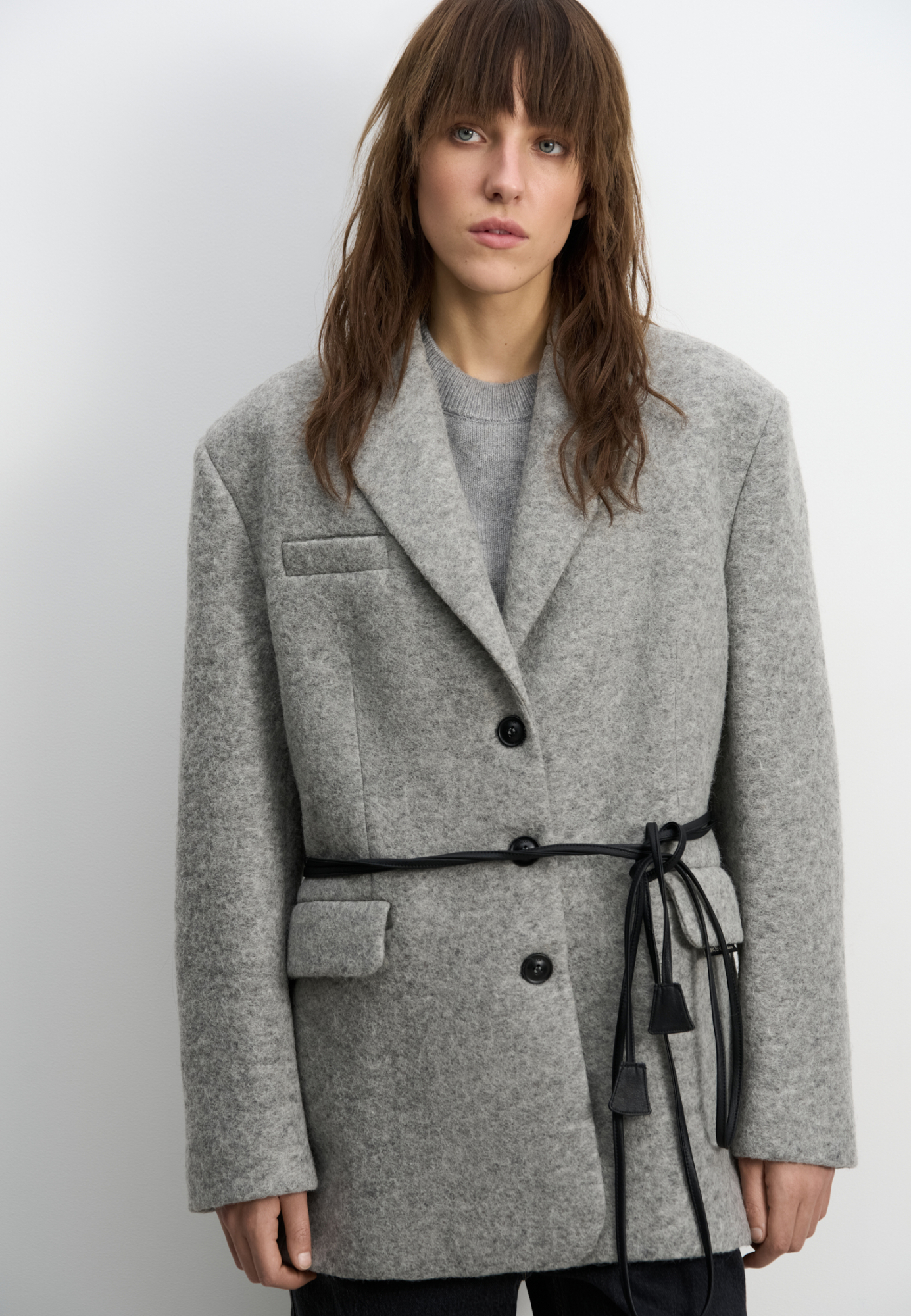 Однобортный жакет-пальто из шерсти. Модель прямого кроя с классическим отложным воротником и двумя прорезными карманами с клапанами. Застежка на пуговицы. Изделие декорировано пуговицами на манжетах и брендированным ярлыком на клапане кармана. Пояс из экокожи в комплекте. Пальто на подкладке. 