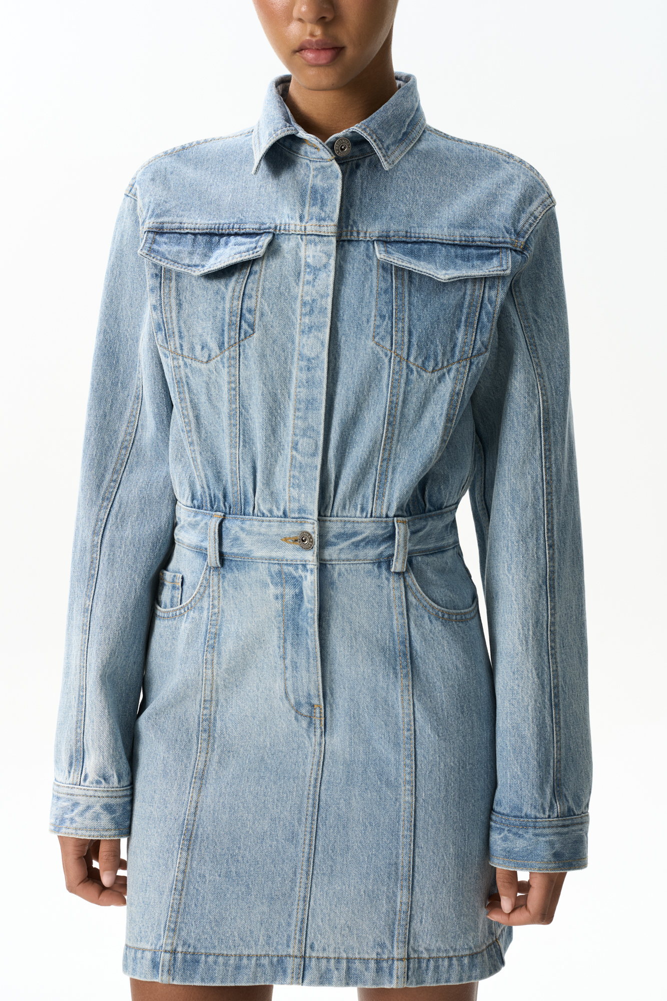 Джинсовое платье длины мини из 100% хлопка. Модель приталенного силуэта, с длинными рукавами, отложным воротником, нагрудными карманами с клапанами, боковыми карманами и патами на поясе для ремня. Застежка на металлические кнопки.