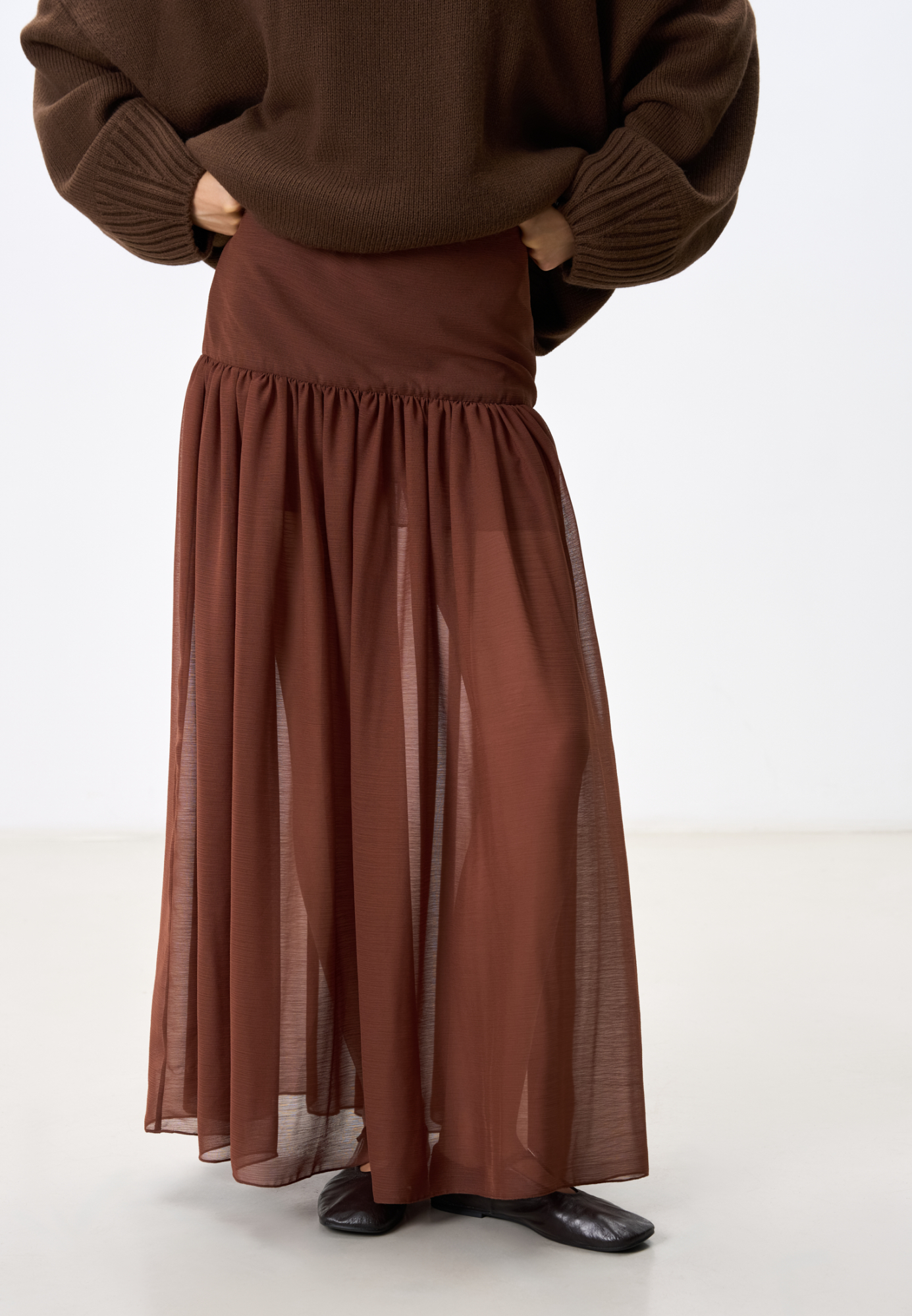 Юбка длины макси из шифоновой ткани. Модель А-силуэта с широкой кокеткой и мягкими складками. Изделие дополнено незаметной застежкой-молнией и миниатюрным крючком.