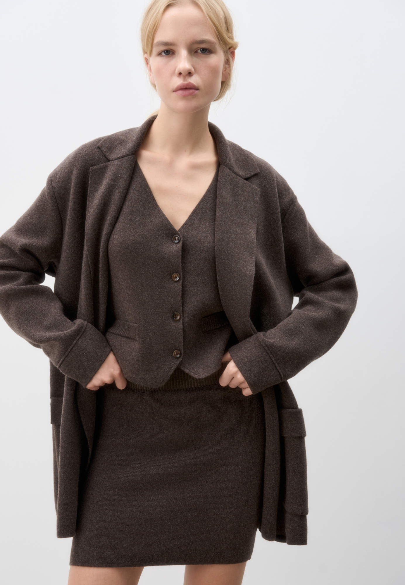 Трикотажный двубортный жакет из смесовой шерсти с добавлением кашемира. Модель прямого кроя, с прямоугольными лацканами и накладными карманами с клапанами спереди. Изделие без подкладки.