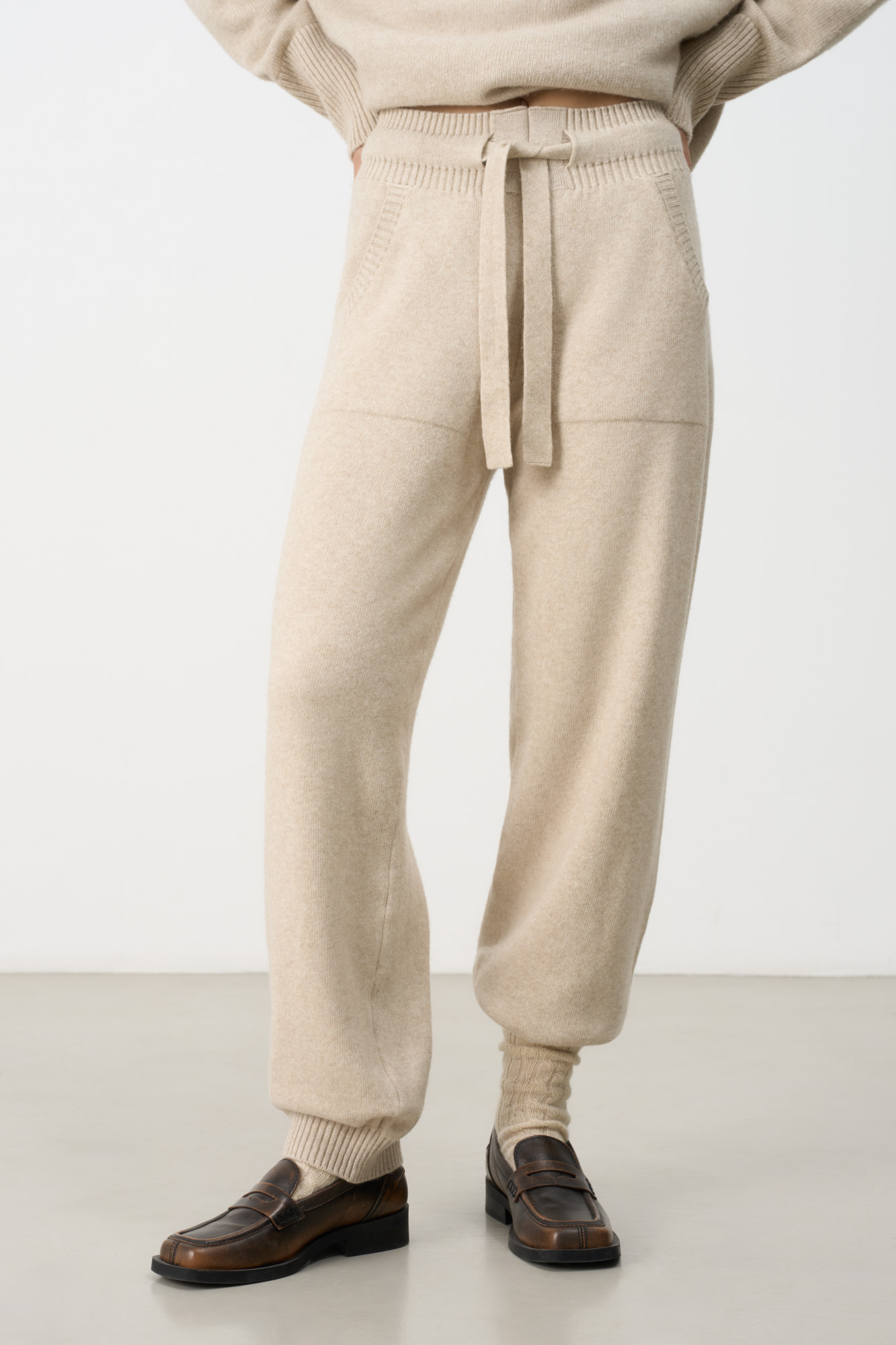 Трикотажные брюки-джоггеры из кашемира и шерсти. Модель с широким эластичным поясом на кулиске, манжетами на резинке и боковыми карманами.