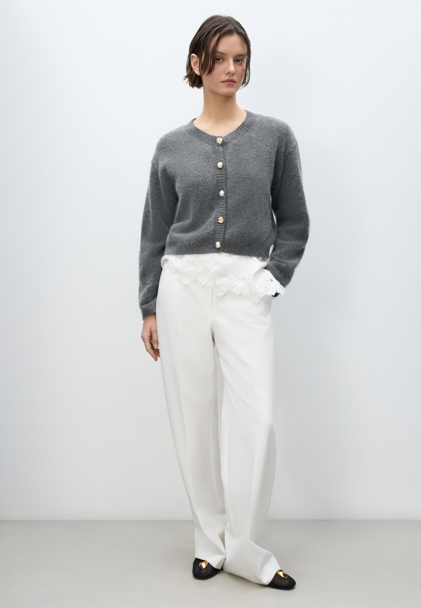 Трикотажный кардиган из пуха лисы. Модель свободного силуэта со спущенной линией плеч и круглым вырезом горловины. Изделие декорировано крупными акцентными пуговицами.