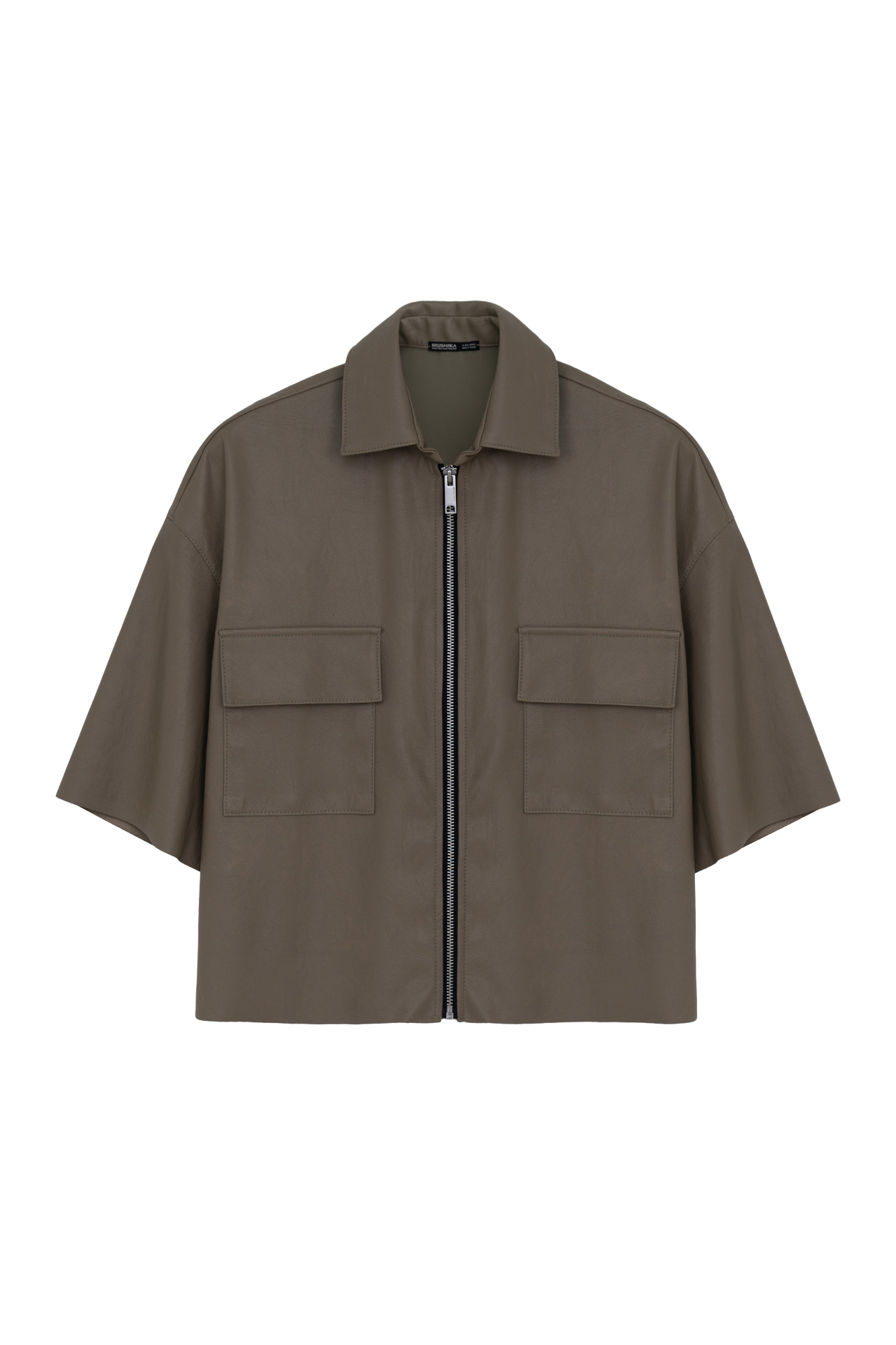 Укороченная рубашка из экокожи. Модель свободного силуэта со спущенной линией плеча, накладными карманами на груди и застежкой на молнию.