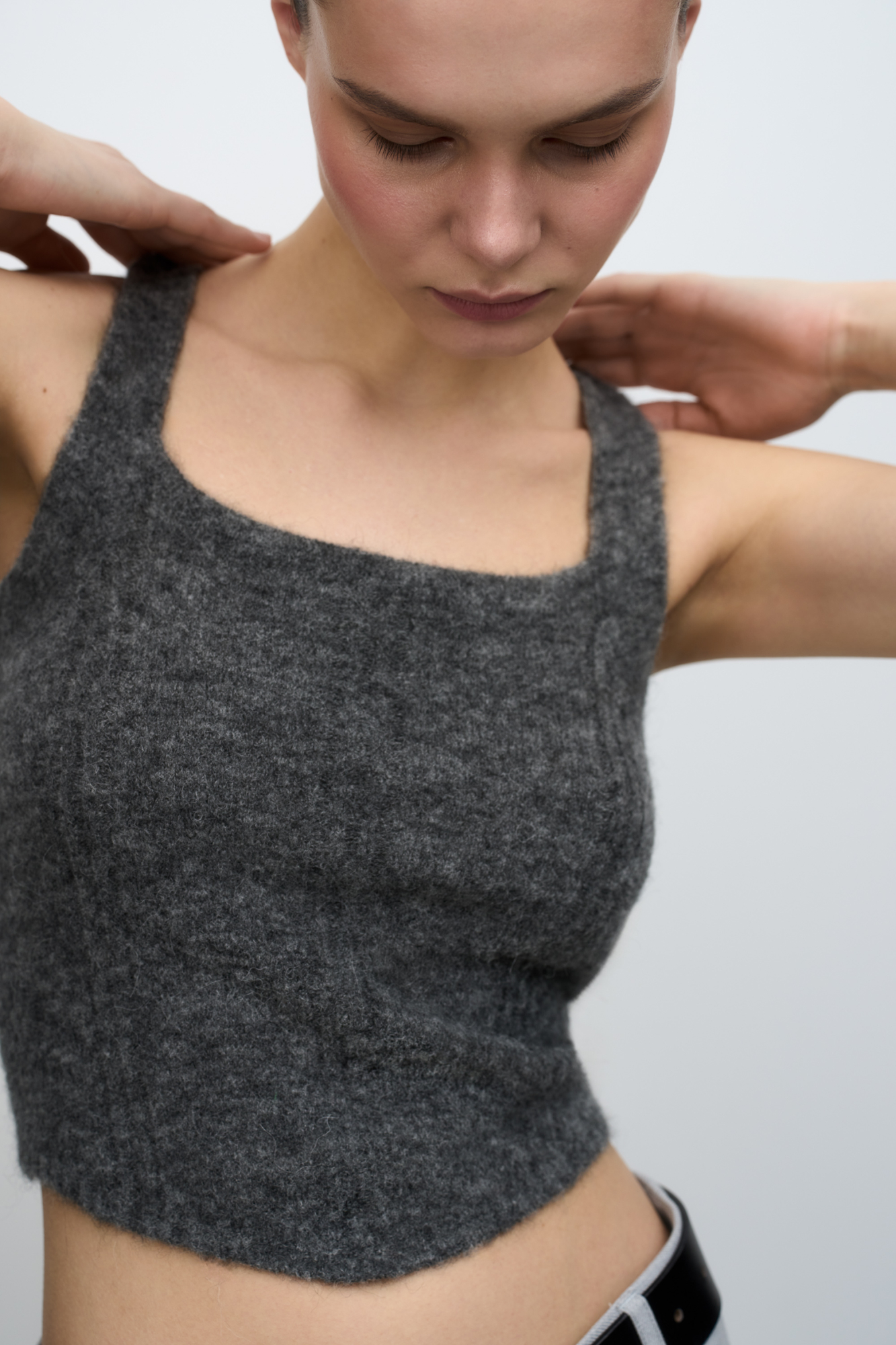 Трикотажный укороченный топ из шерсти альпака. Модель на бретелях. Дополнить образ можно кардиганом из того же материала.