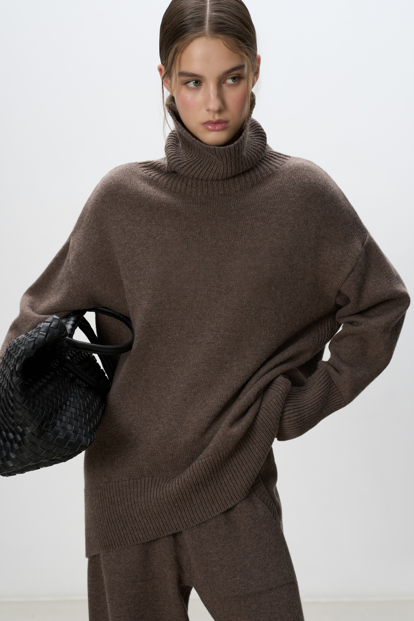 Трикотажный джемпер из мягкой шерсти с добавлением кашемира. Высокий ворот, заниженная линия плеч, удлиненная спинка. Края изделия сделаны в широкий рубчик. Можно дополнить комплектными брюками.