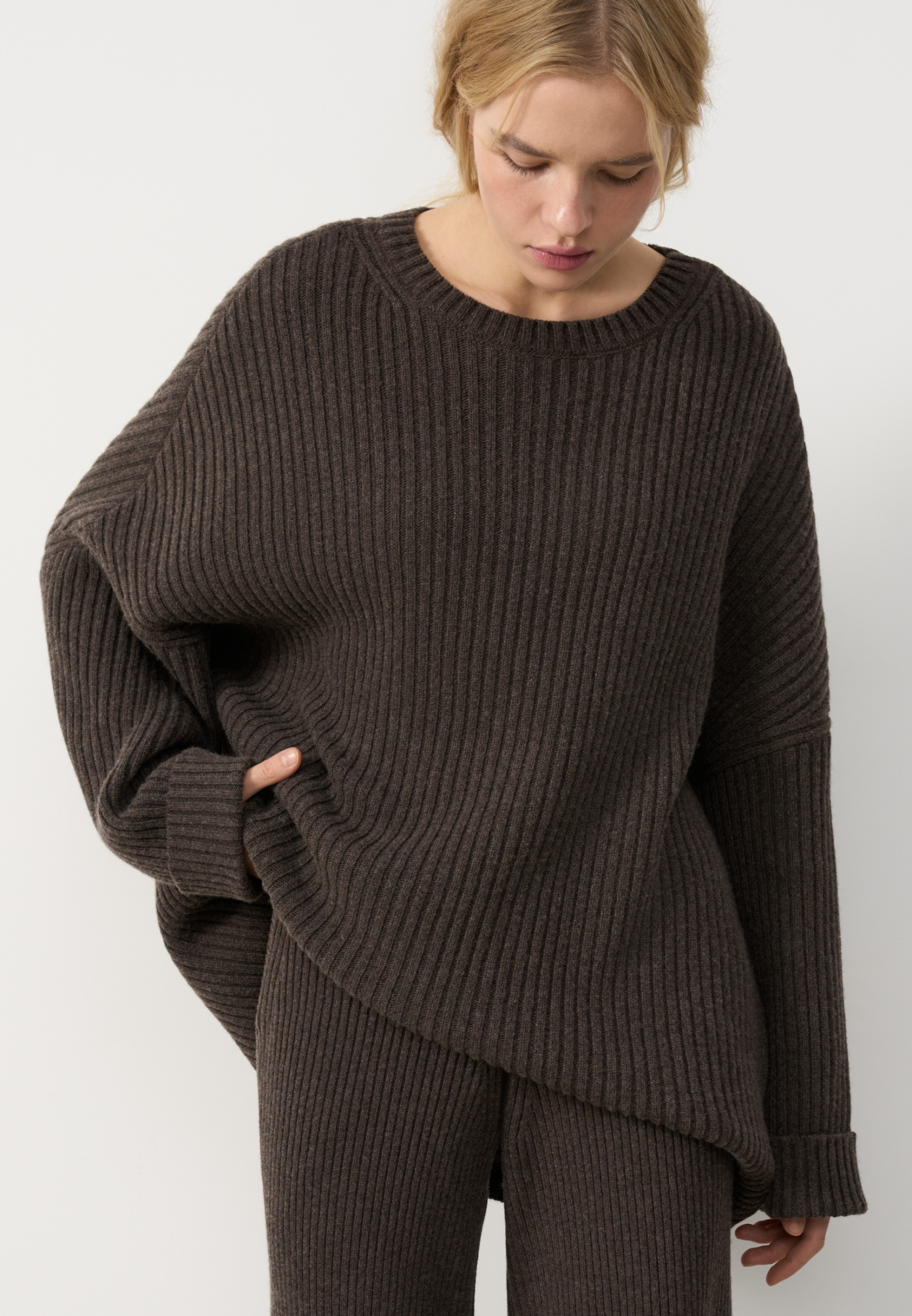 Трикотажный джемпер из шерсти с добавлением кашемира. Модель свободного силуэта со спущенной линией плеча, отворотами на манжетах и круглым вырезом горловины. Изделие выполнено в широкий рубчик.