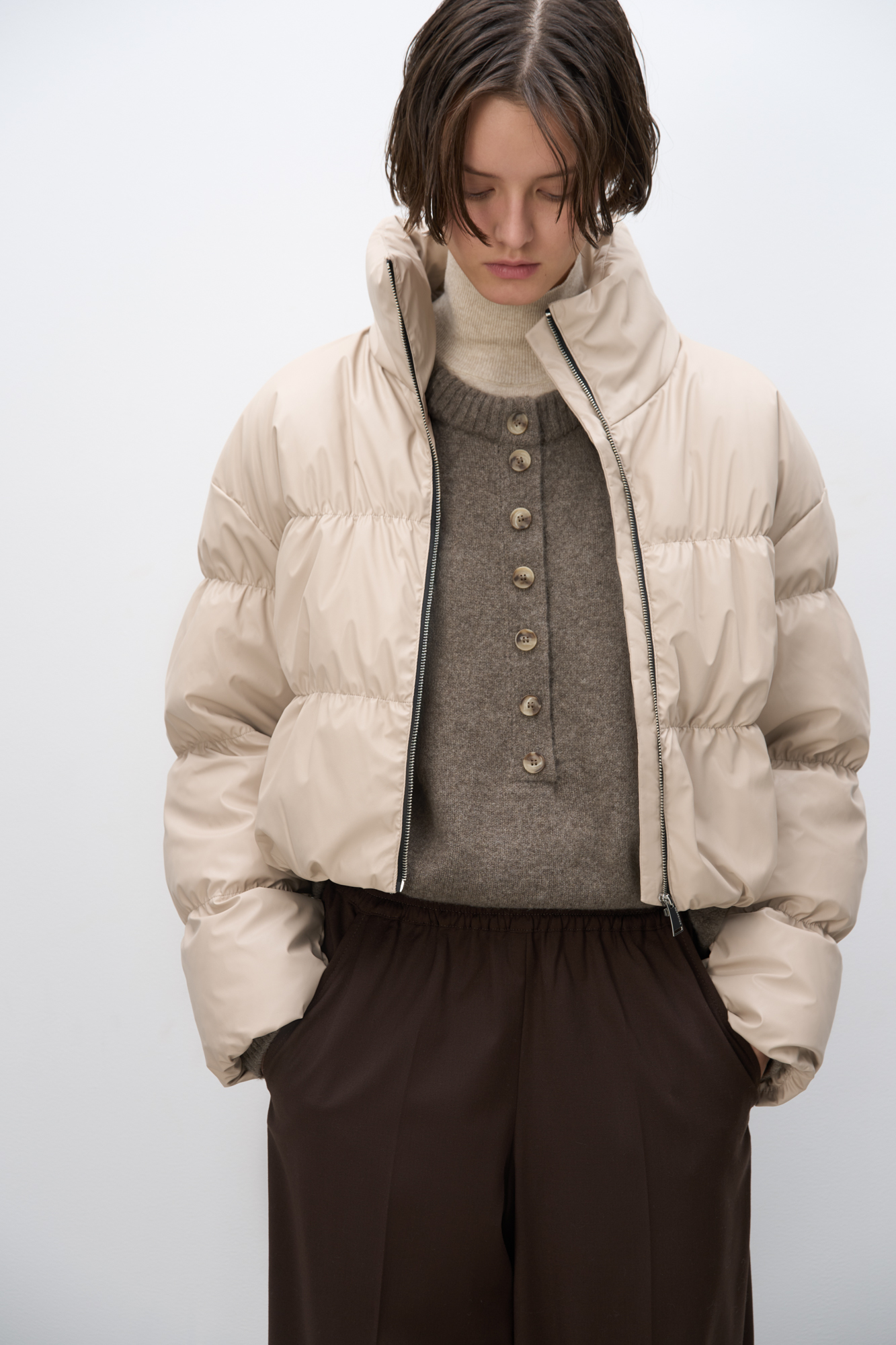 Короткий стеганый пуховик. Модель свободного кроя с воротником стойкой и застежкой на молнию.