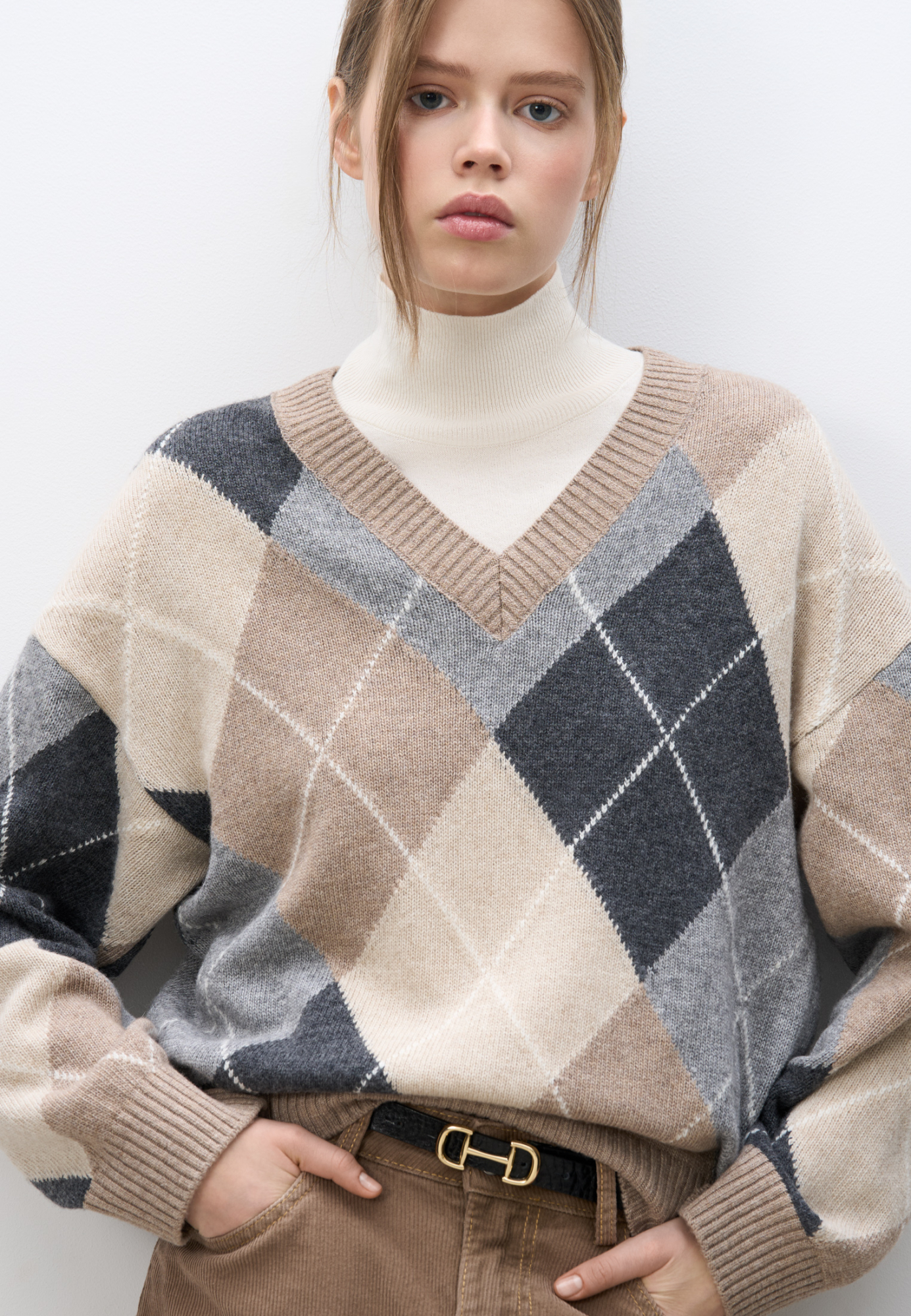 Трикотажный джемпер из кашемира с узором аргайл. Модель свободного силуэта, со спущенной линией плеча и V-вырезом горловины. Края изделия выполнены в рубчик.