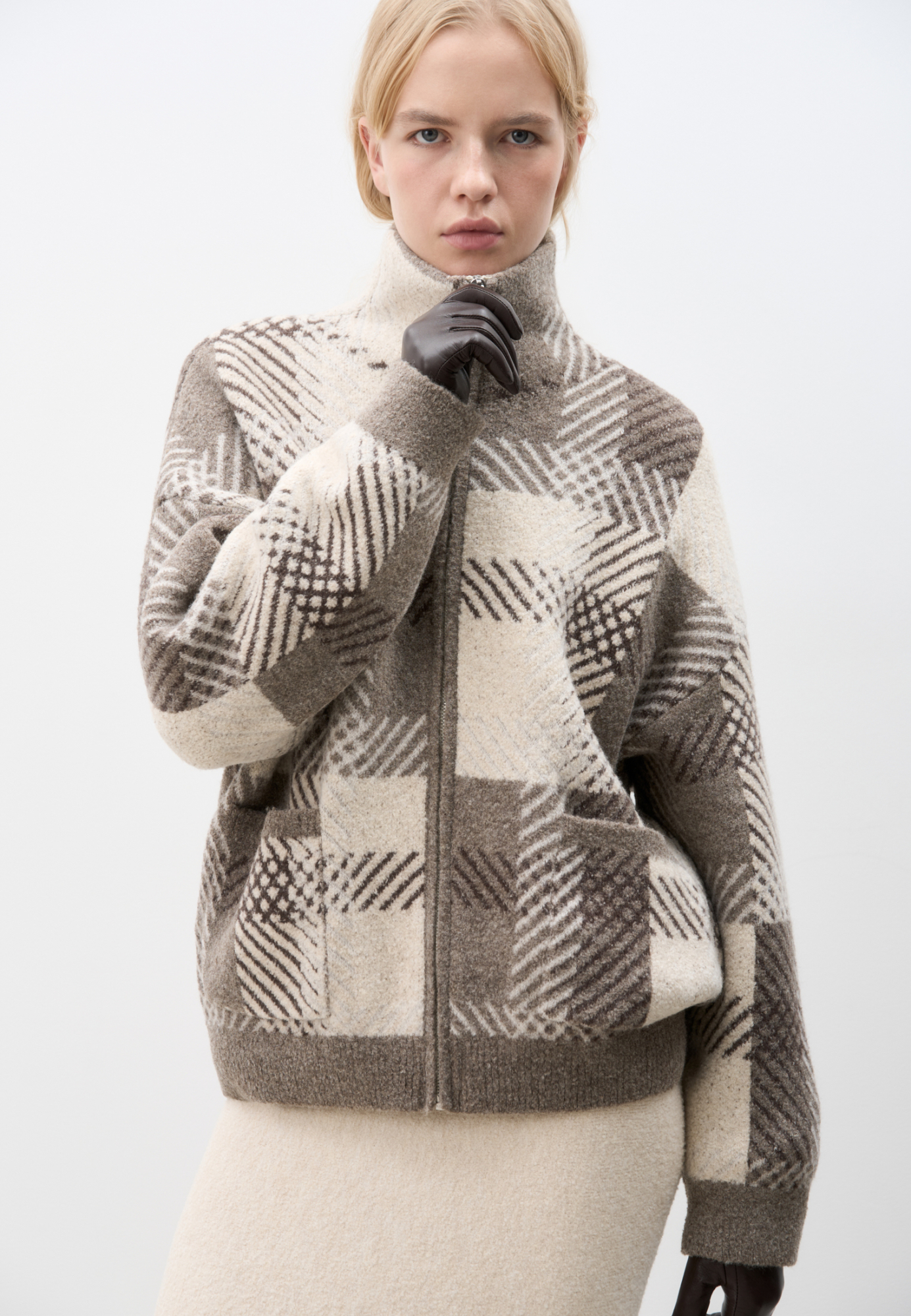 Трикотажный бомбер из смесовой шерсти с добавлением вискозы. Модель свободного кроя со спущенной линией плеч, отложным воротником и накладными карманами. Застежка на молнию. Изделие без подкладки.