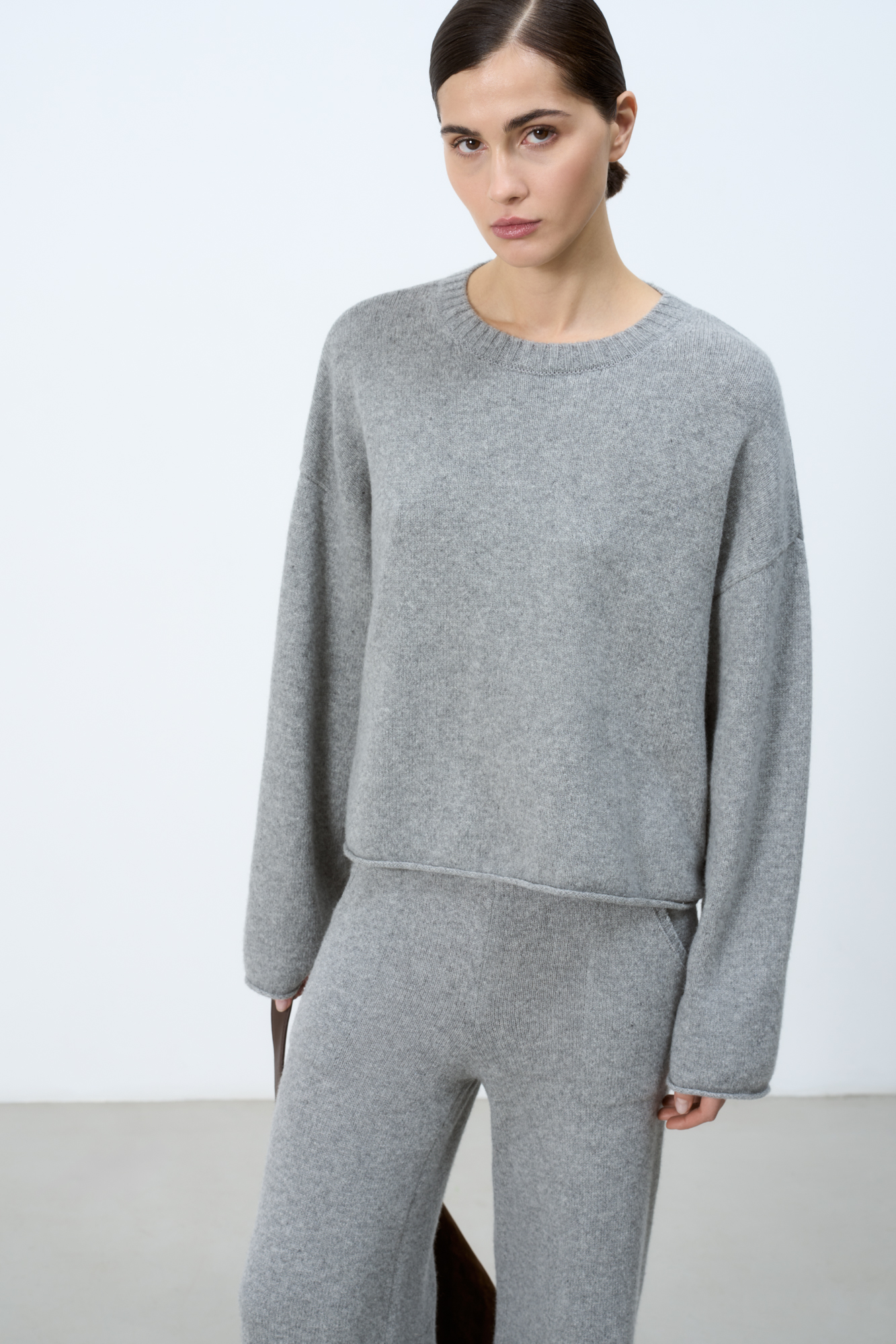 Джемпер из 100% кашемира. Модель свободного силуэта со спущеной линией плеча, круглой горловиной и валиками по низу изделия. 