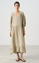 Длинное платье из 100% льна с расклешением от талии и широким асимметричным воланом внизу. Короткий рукав на резинке. V-образный вырез с завязками на спине.