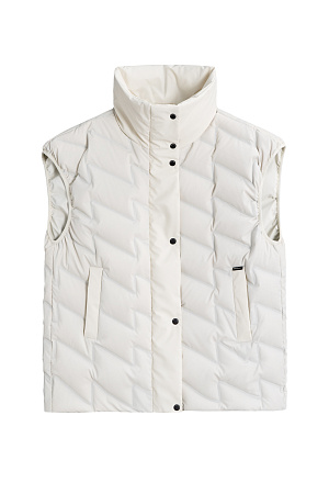 молочный молочный Объемный стеганый жилет на пуху. Модель прямого кроя, с воротником стойкой и боковыми карманами. Застежка на молнию и кнопки под планкой.