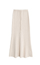 Трикотажная юбка длины макси из буклированной пряжи. Модель по фигуре с расклешенным подолом и поясом, дополненным кулиской. Дополнить образ можно джемпером в таком же стиле. 
